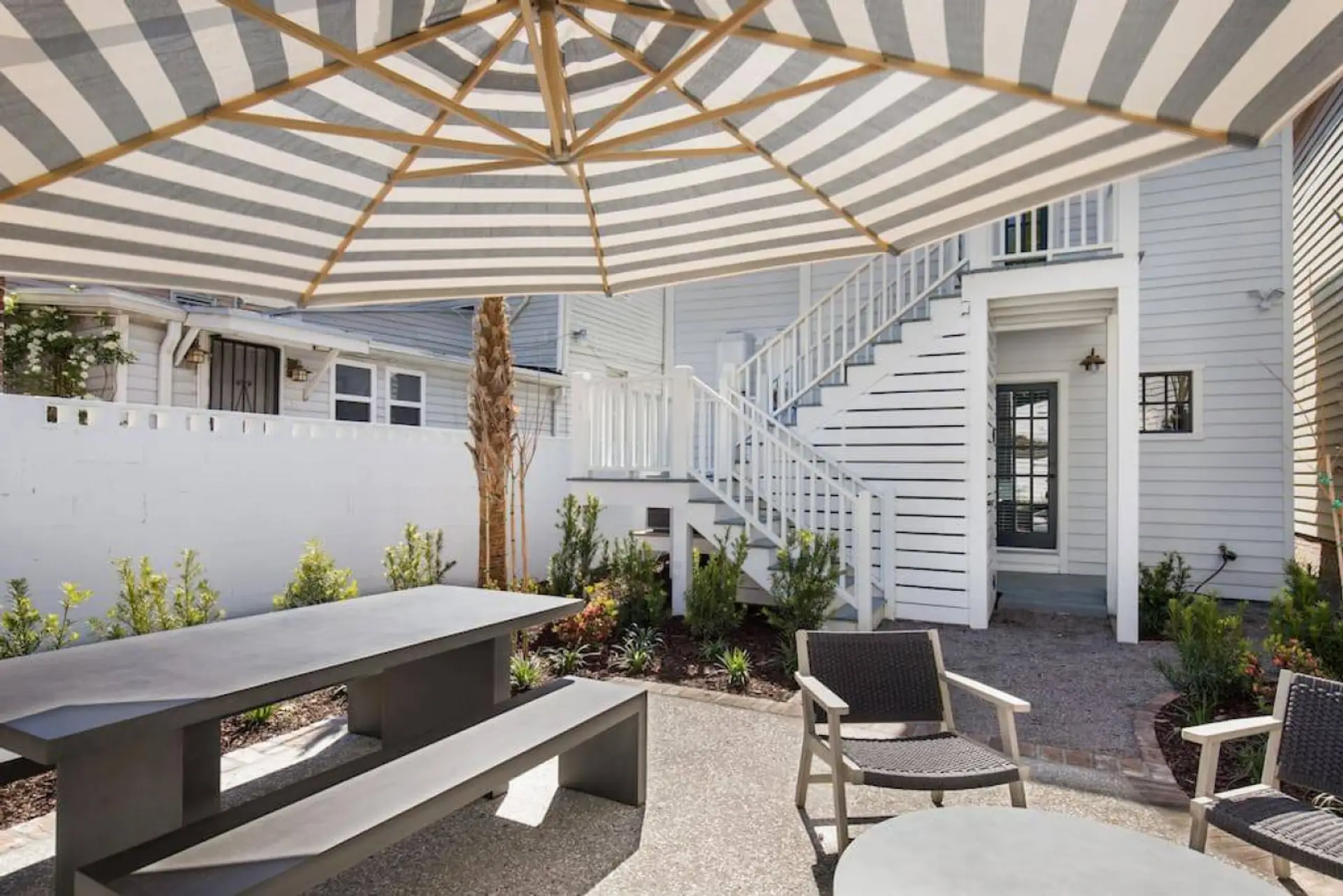 Outdoor dining under the umbrella in the fenced garden, with seating for 6. Shared with the upstairs unit when it is booked.