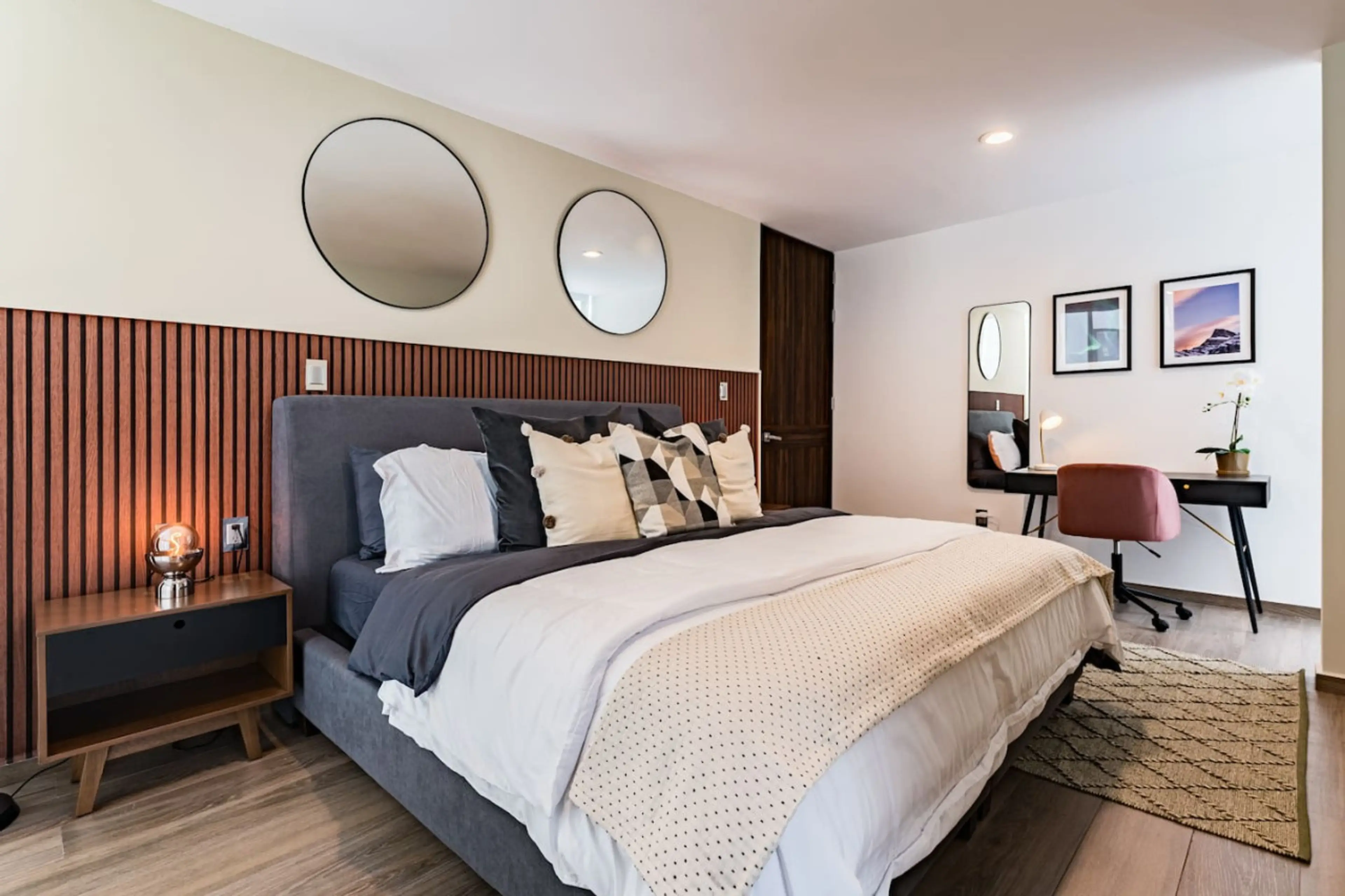 Spacious master bedroom with chic decor, cozy linens, and ambient lighting.