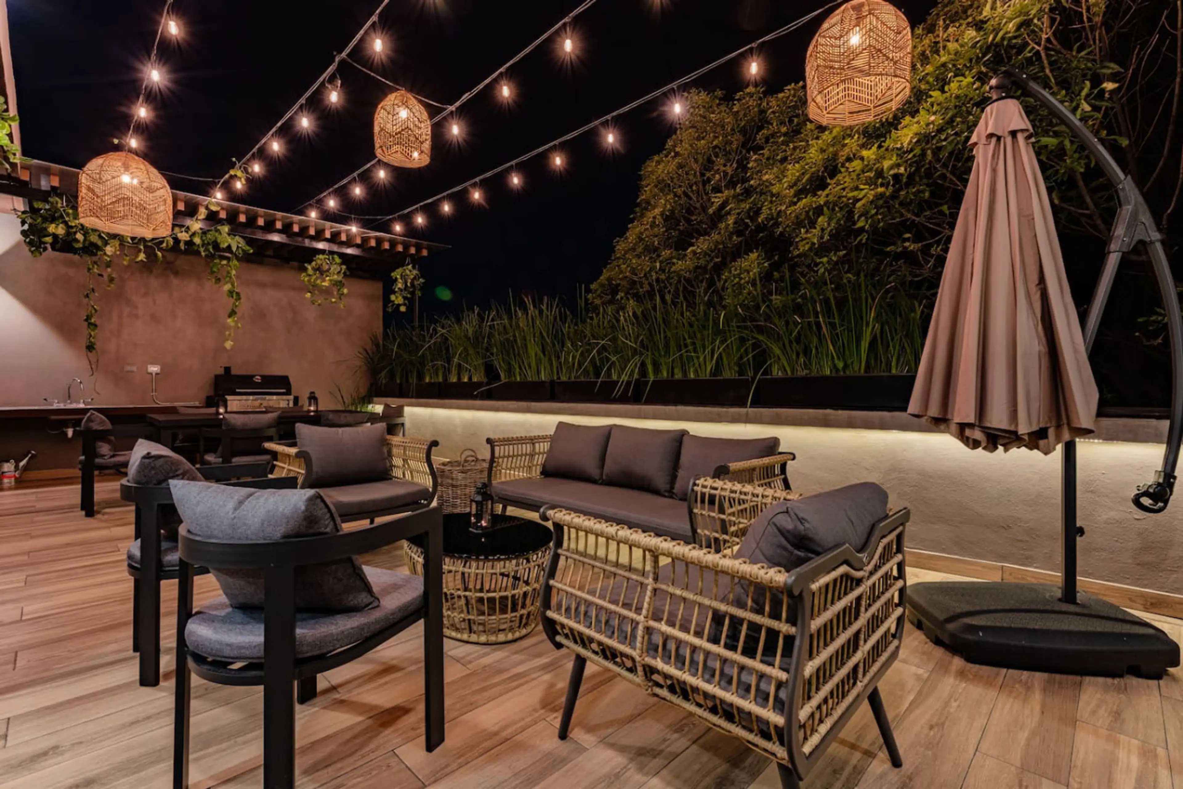 A cozy, well-lit rooftop patio with stylish seating, string lights, and a relaxing ambiance.