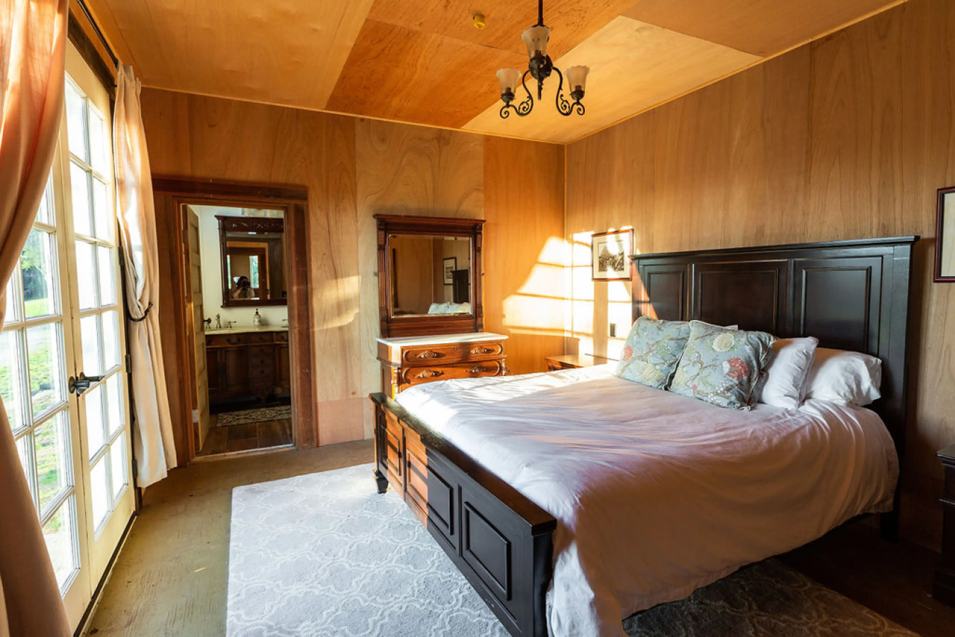 Luxuriate in the beautiful wood panneled master bedroom with back patio access through stunning  Victorian doors.