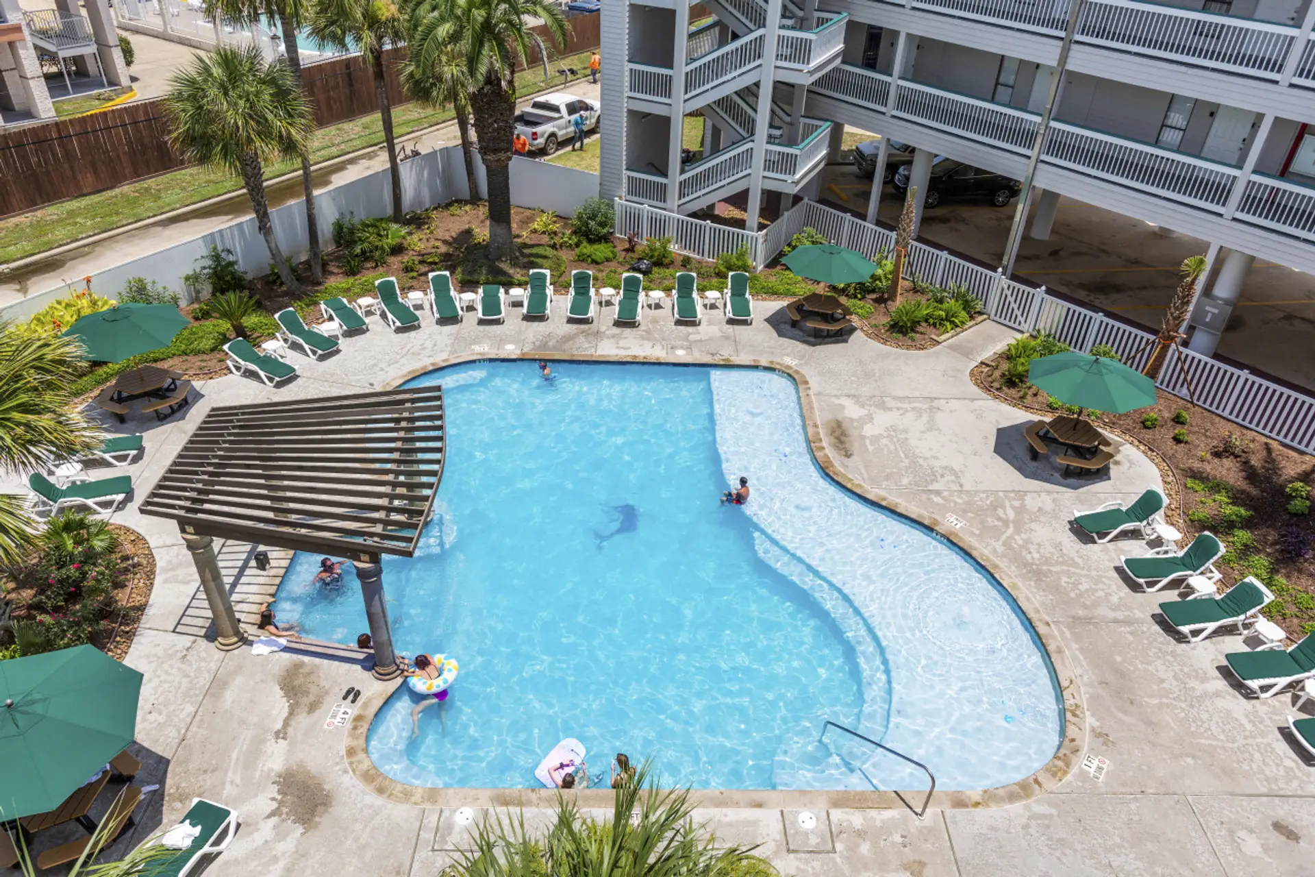 Bird's eye view of the pool, loungers, and poolside relaxation.