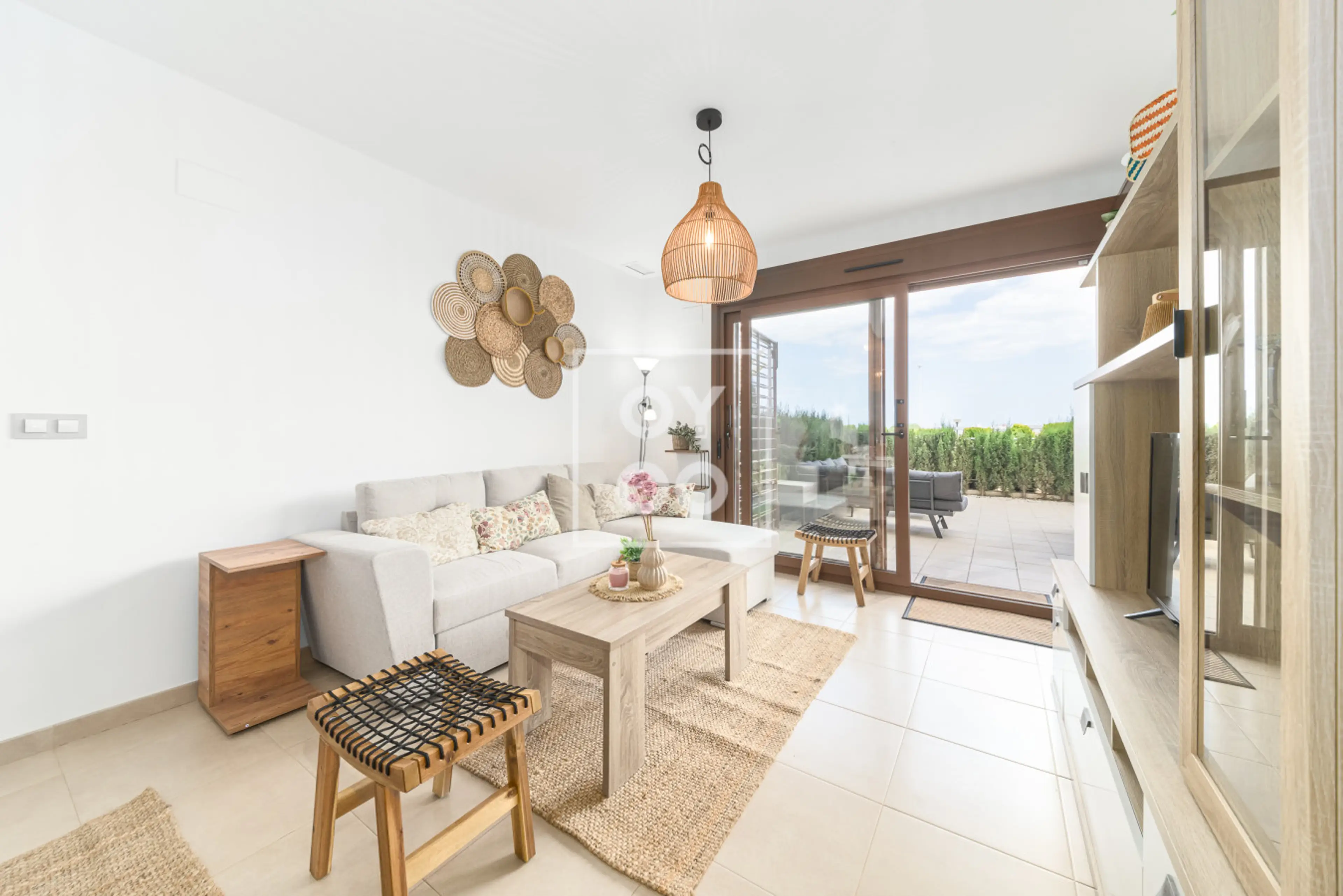 Open-concept living room with plush sofa, natural wood coffee table and stylish rattan accents. Flooded with sunlight, it seamlessly connects to the outdoor terrace for easy indoor-outdoor living 🌞🛋️