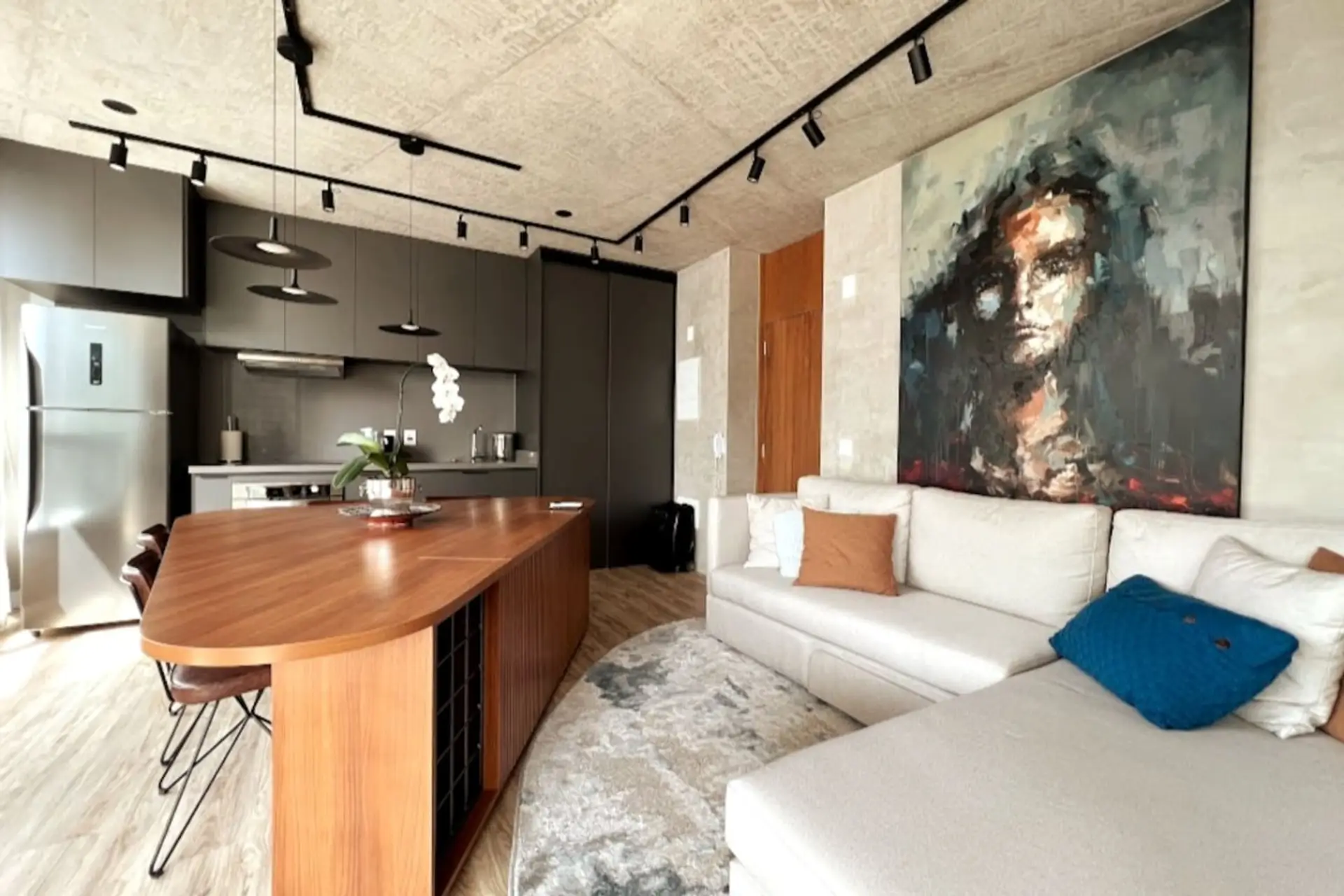 Design sofisticado e moderno. Quadros com arte exclusiva, cozinha completa com ilha em madeira, ambientes aconchegantes, com um sofá espaçoso e confortável para relaxar.