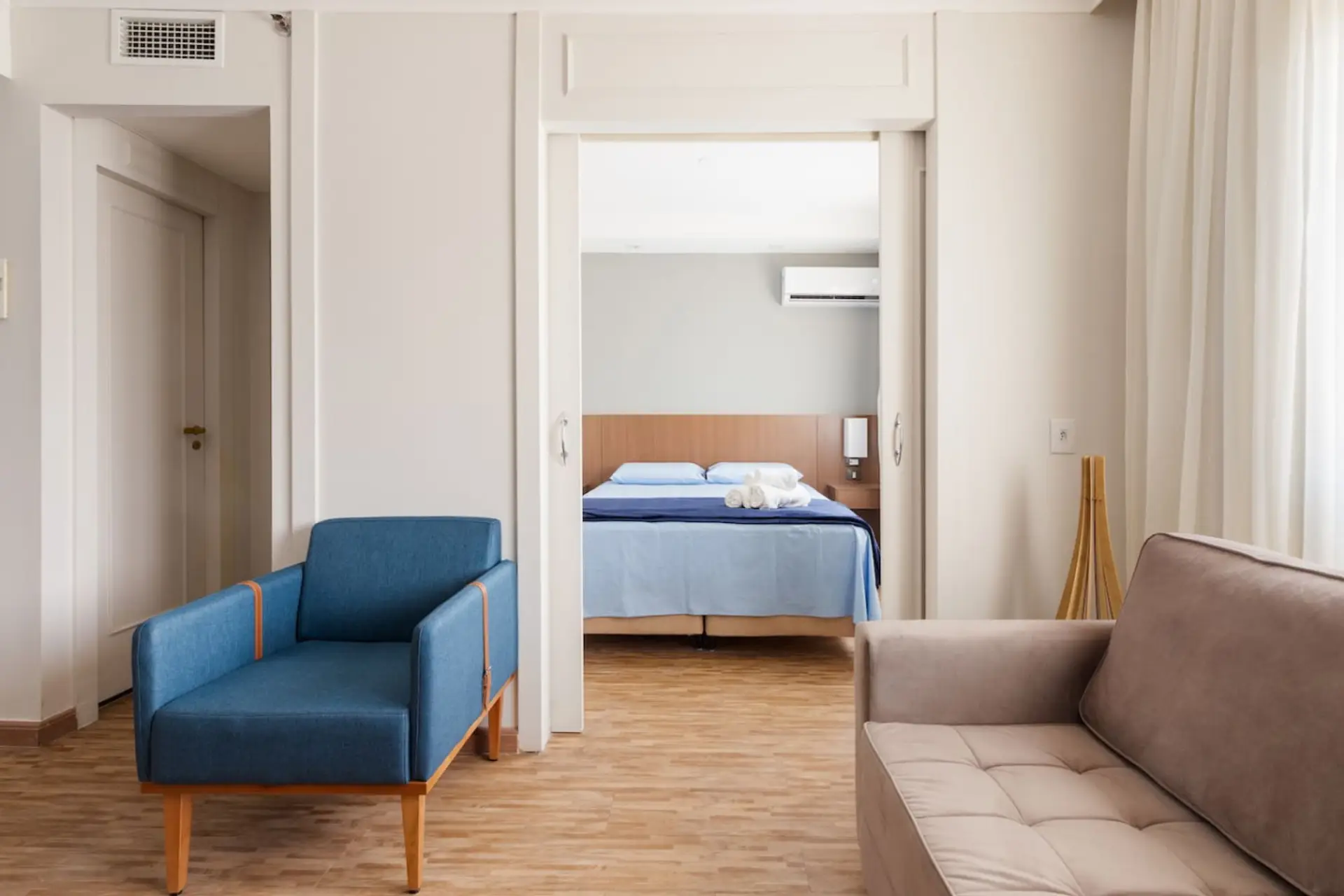 Ambiente acolhedor e bem planejado: sala de estar integrada ao quarto, com móveis modernos e tons neutros que proporcionam conforto e praticidade para sua estadia.