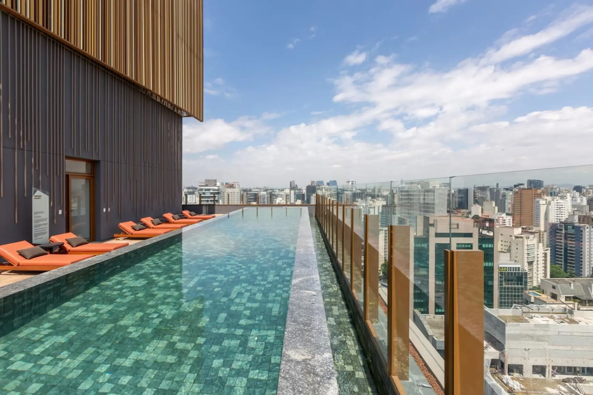 Piscina de borda infinita com vista espetacular para a cidade! Um espaço perfeito para relaxar, tomar sol nas espreguiçadeiras confortáveis e aproveitar momentos incríveis no rooftop desse prédio moderno e sofisticado.