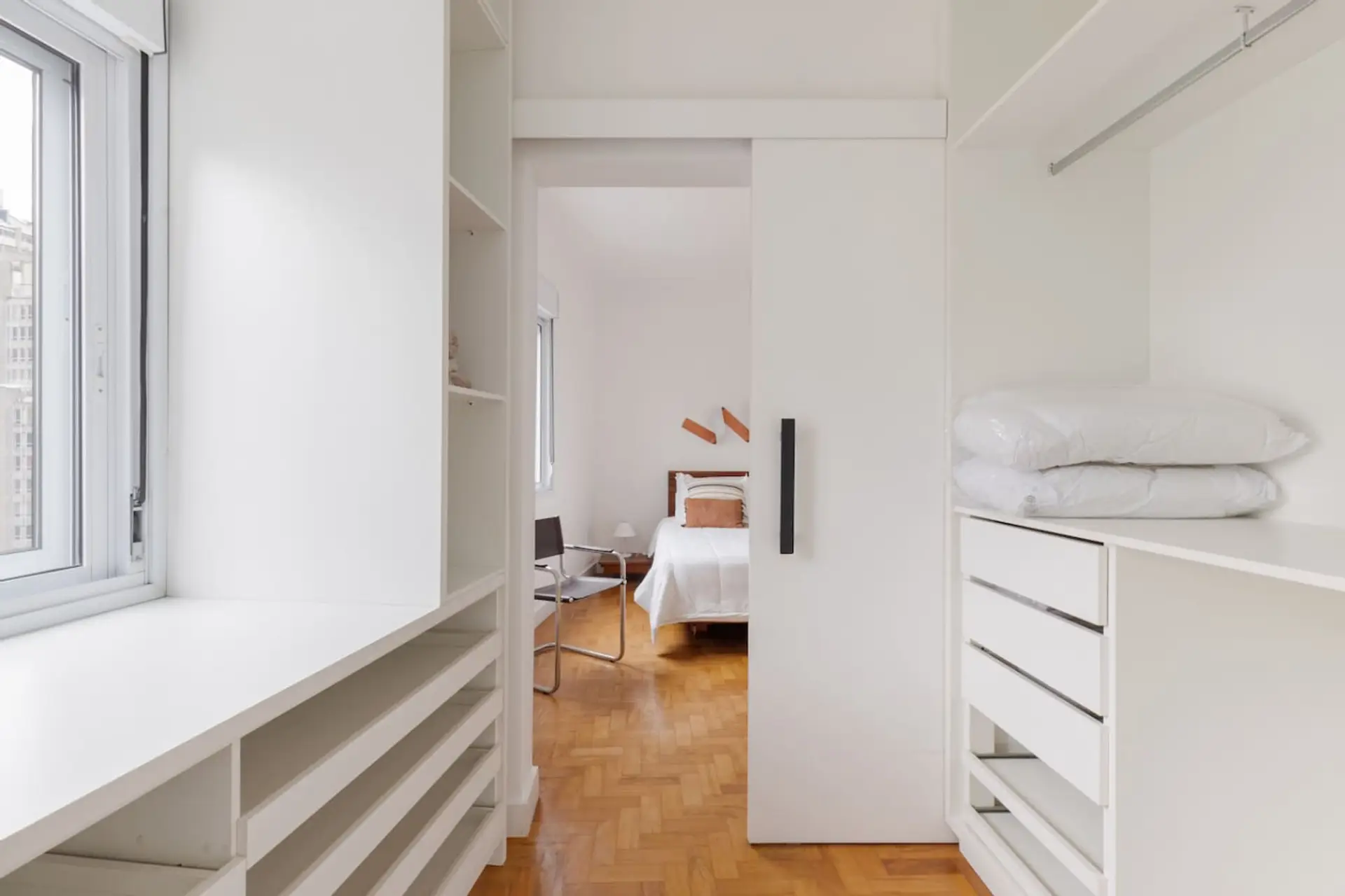 Closet amplo, iluminado e funcional, com armários planejados e excelente espaço para organização. A conexão direta com o quarto garante praticidade e fluidez ao ambiente.