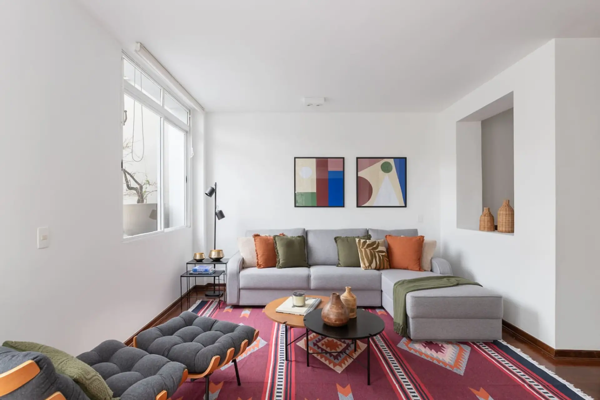 Ambiente iluminado e acolhedor: uma sala de estar perfeita para relaxar após um dia de passeio, com sofá espaçoso, decoração moderna e toques de cor que trazem vida ao espaço.