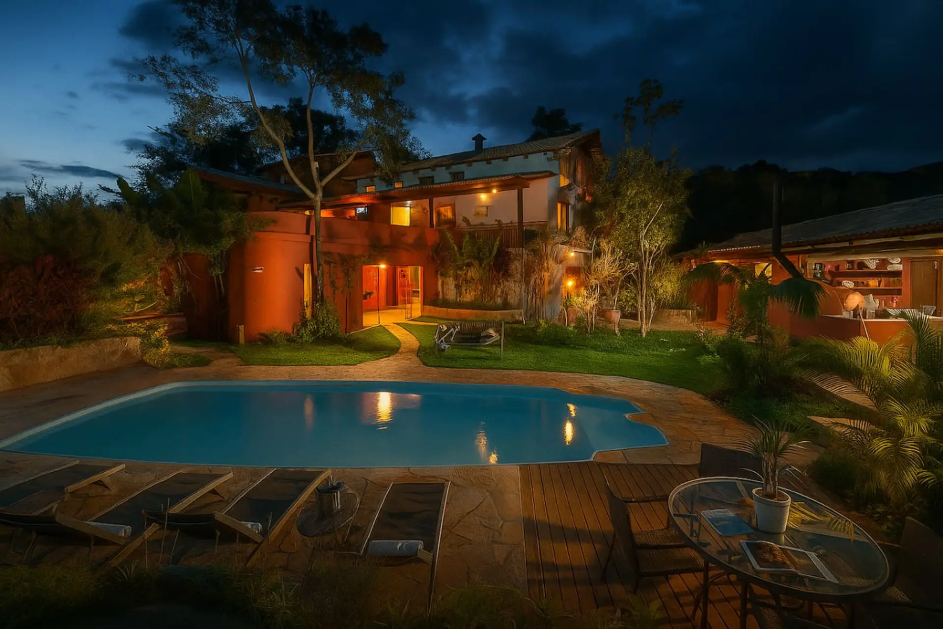 Piscina iluminada à noite em um cenário encantador, perfeita para momentos de lazer e relaxamento em um ambiente acolhedor.