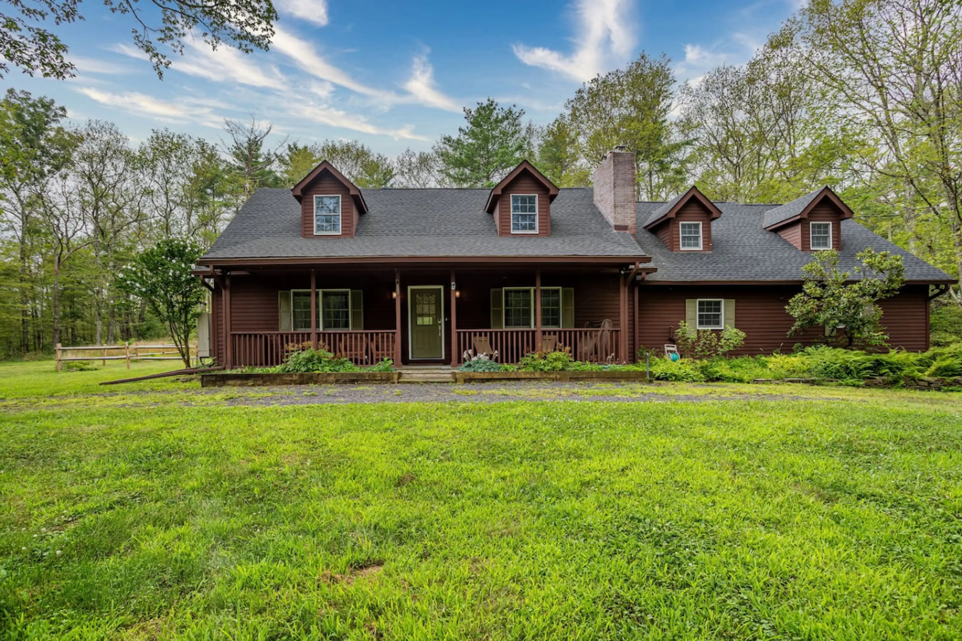 Charming country cabin surrounded by lush greenery, offering a peaceful family retreat.