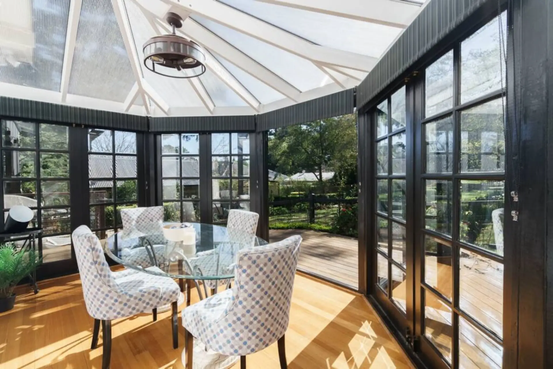 Sunroom with dining table and seating for 4 guests.