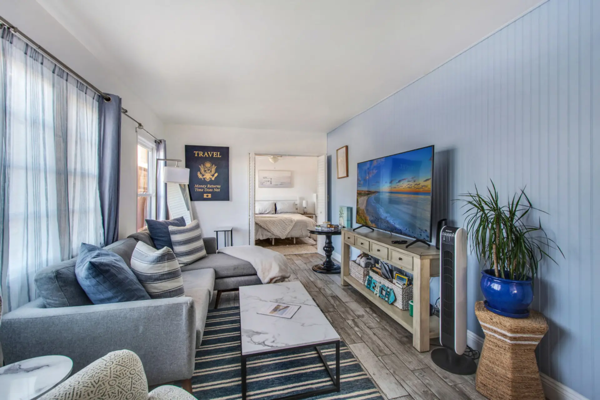 Stylish and cozy living space with a seaside vibe, smart TV, and a view of the bedroom.