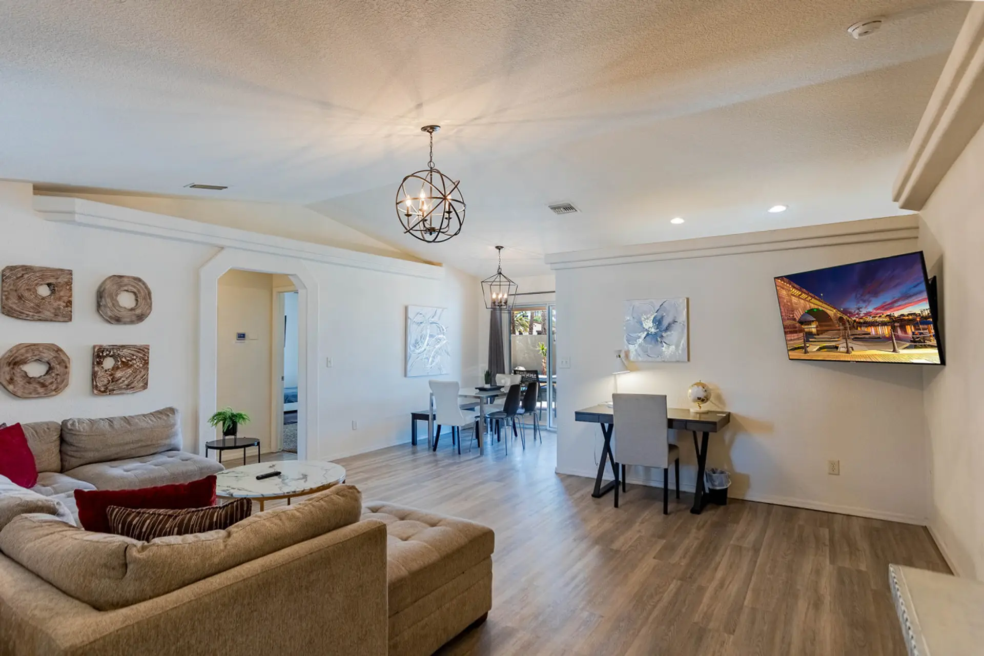 Large living room with comfy couch, TV, and desk.