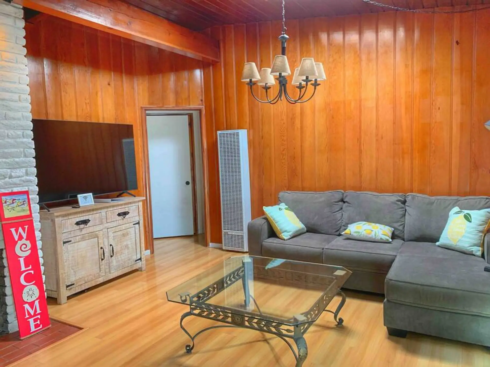 Cozy room with wood-paneled walls, a comfy sofa, and warm decor.