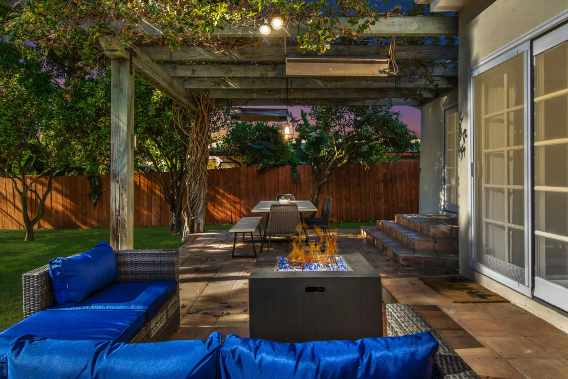 Enjoy cozy evenings by the fire pit, dine al fresco under the pergola