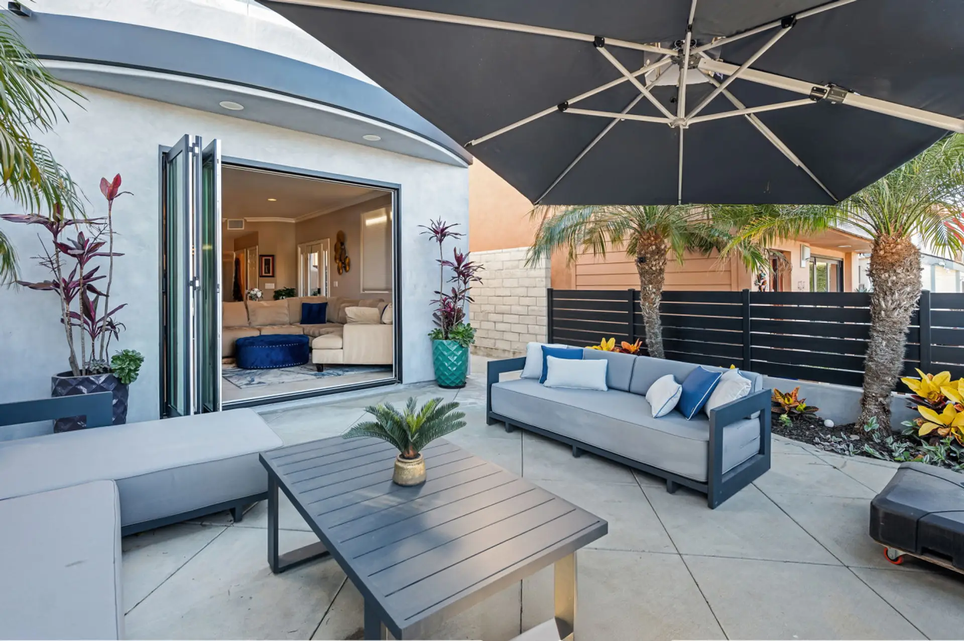 This stunning coastal home opens up to a lush patio, where relaxation meets the ocean breeze.
