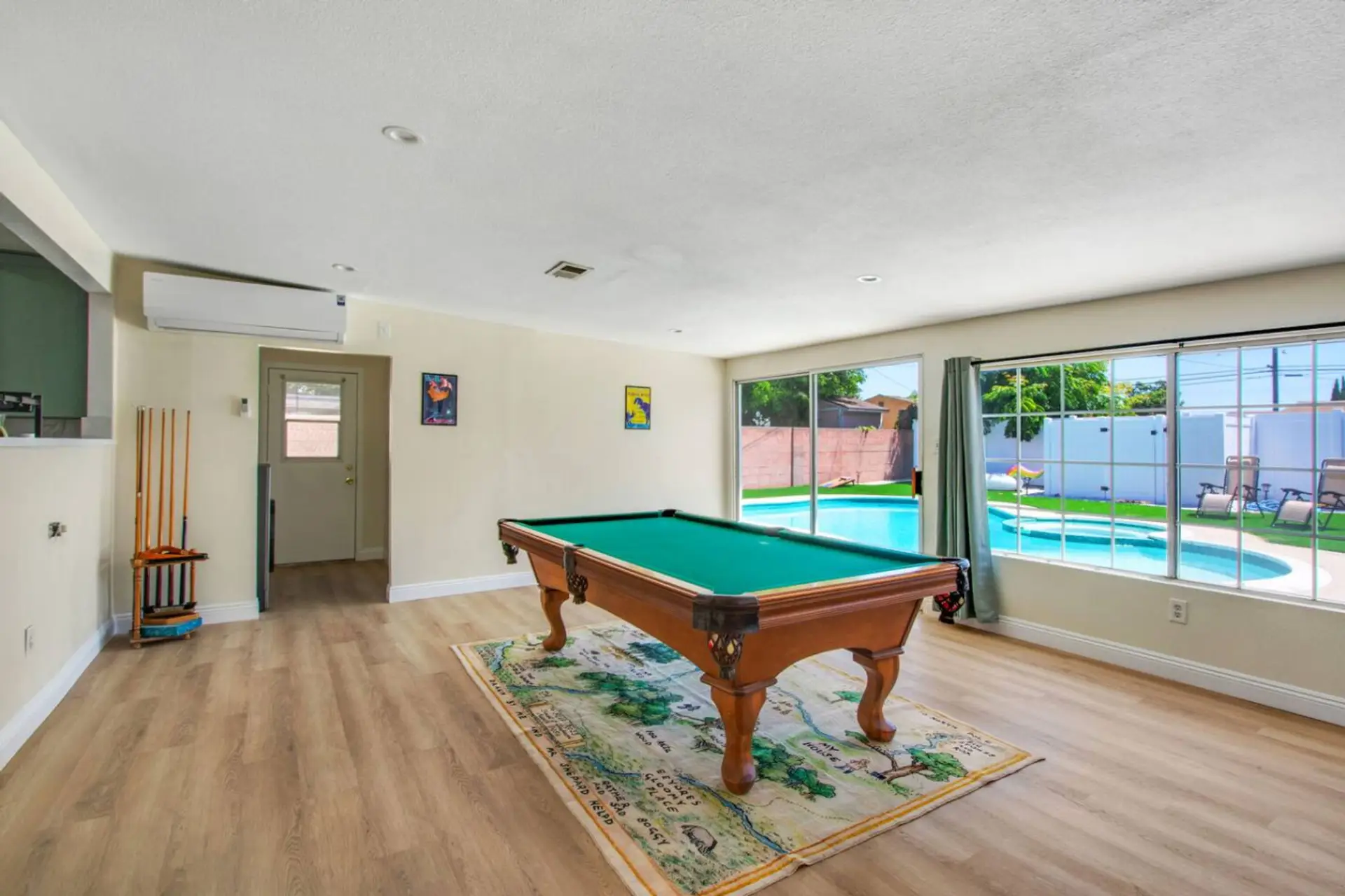 Open concept living and dining area with comfortable sofa seating, smart TV, and a pool table for endless fun.