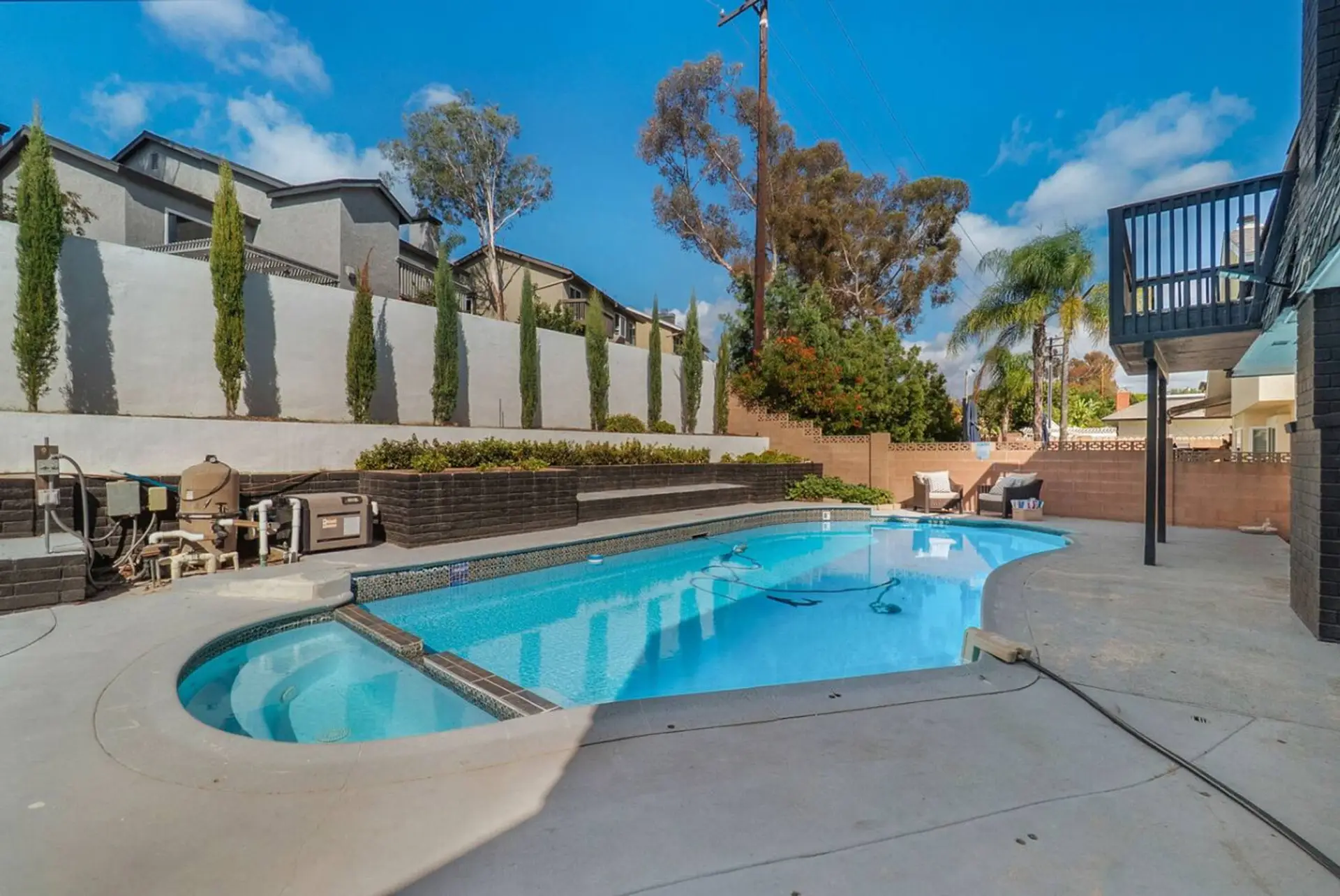 Private pool with lounge space and trees.