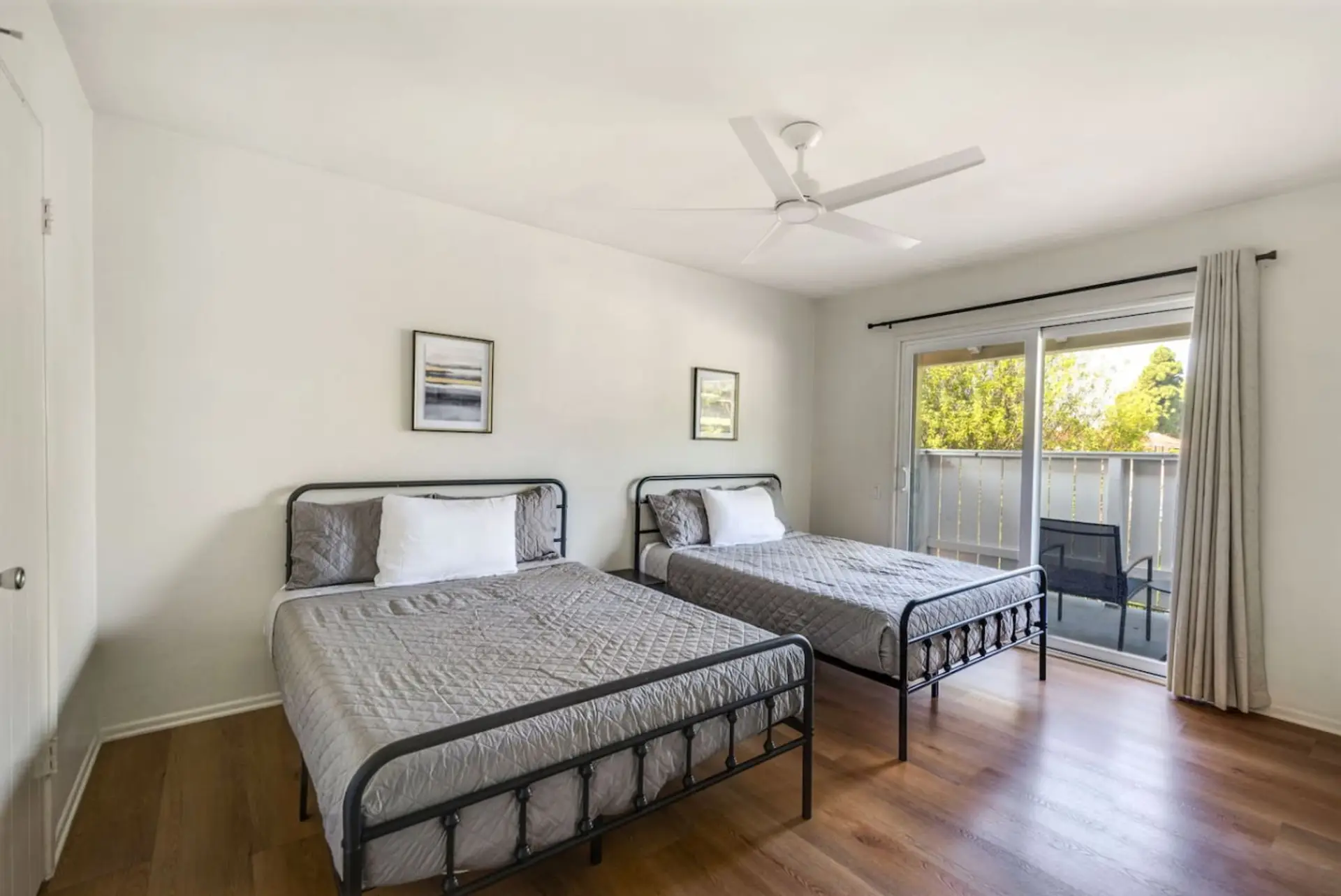 Spacious bedroom with two cozy beds and balcony access for fresh morning air.