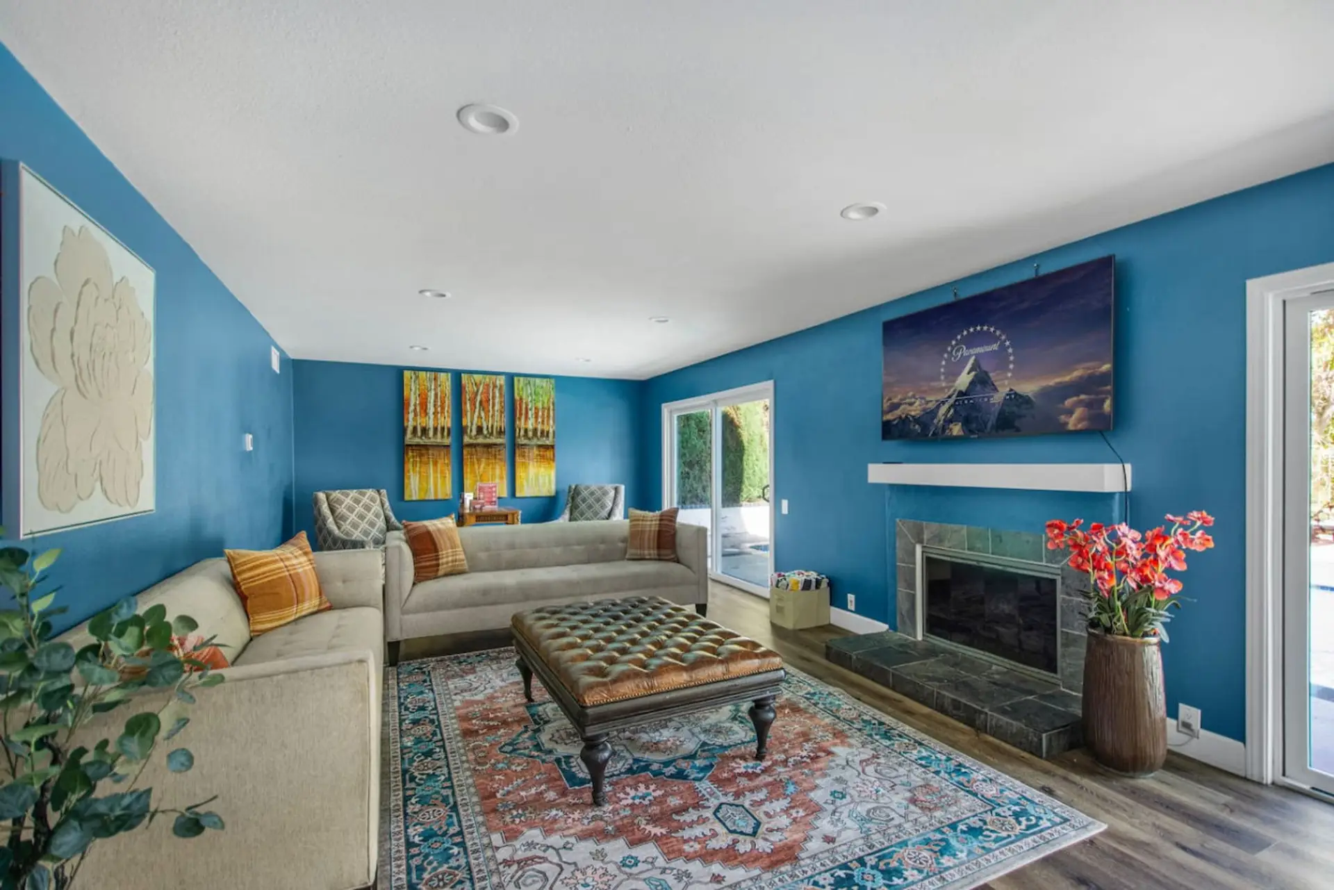 Open-concept living room with comfortable couch seating, Smart TV, and decorative fireplace.