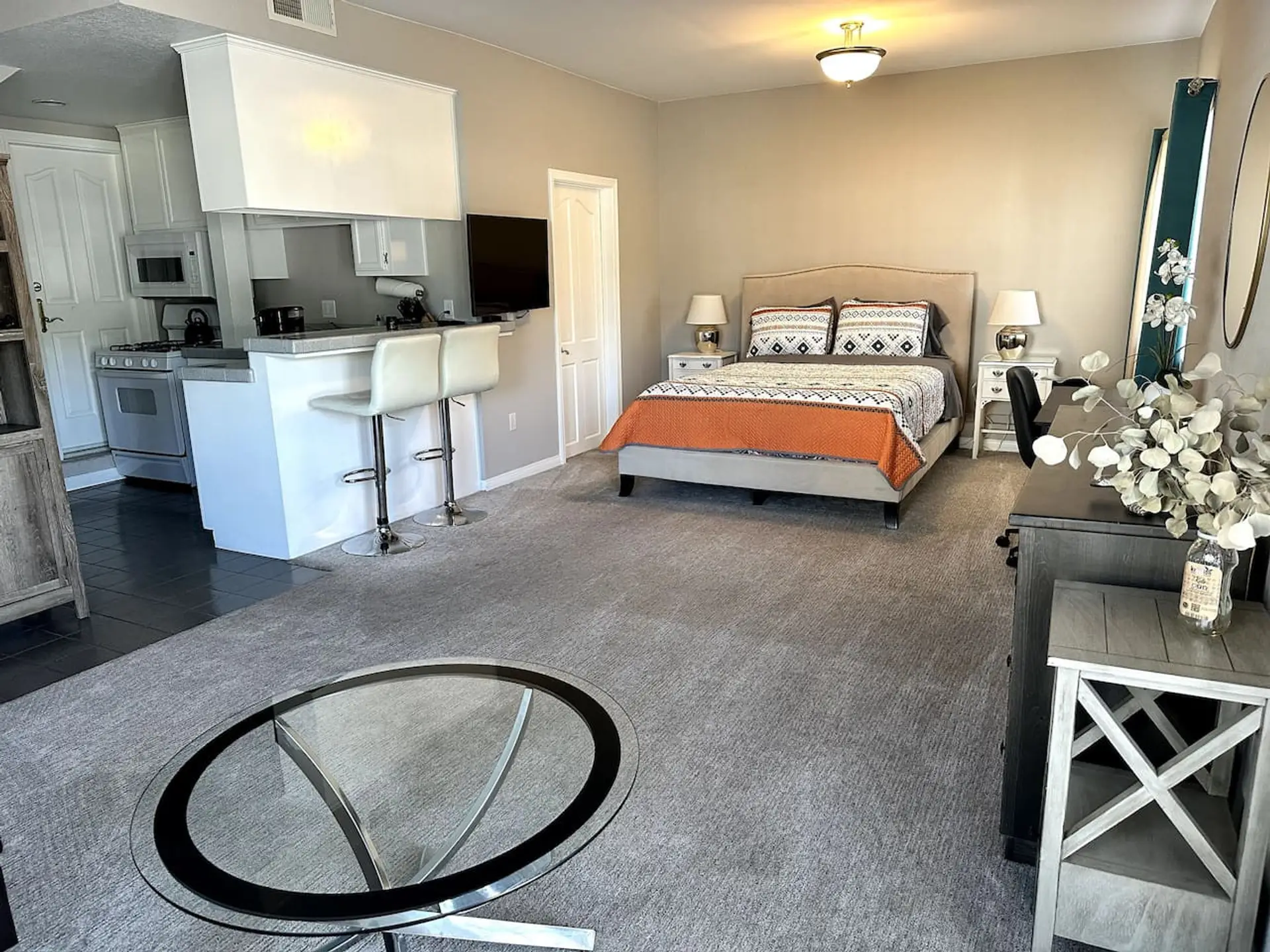 Spacious bedroom with a queen bed, dresser, and plenty of open space.