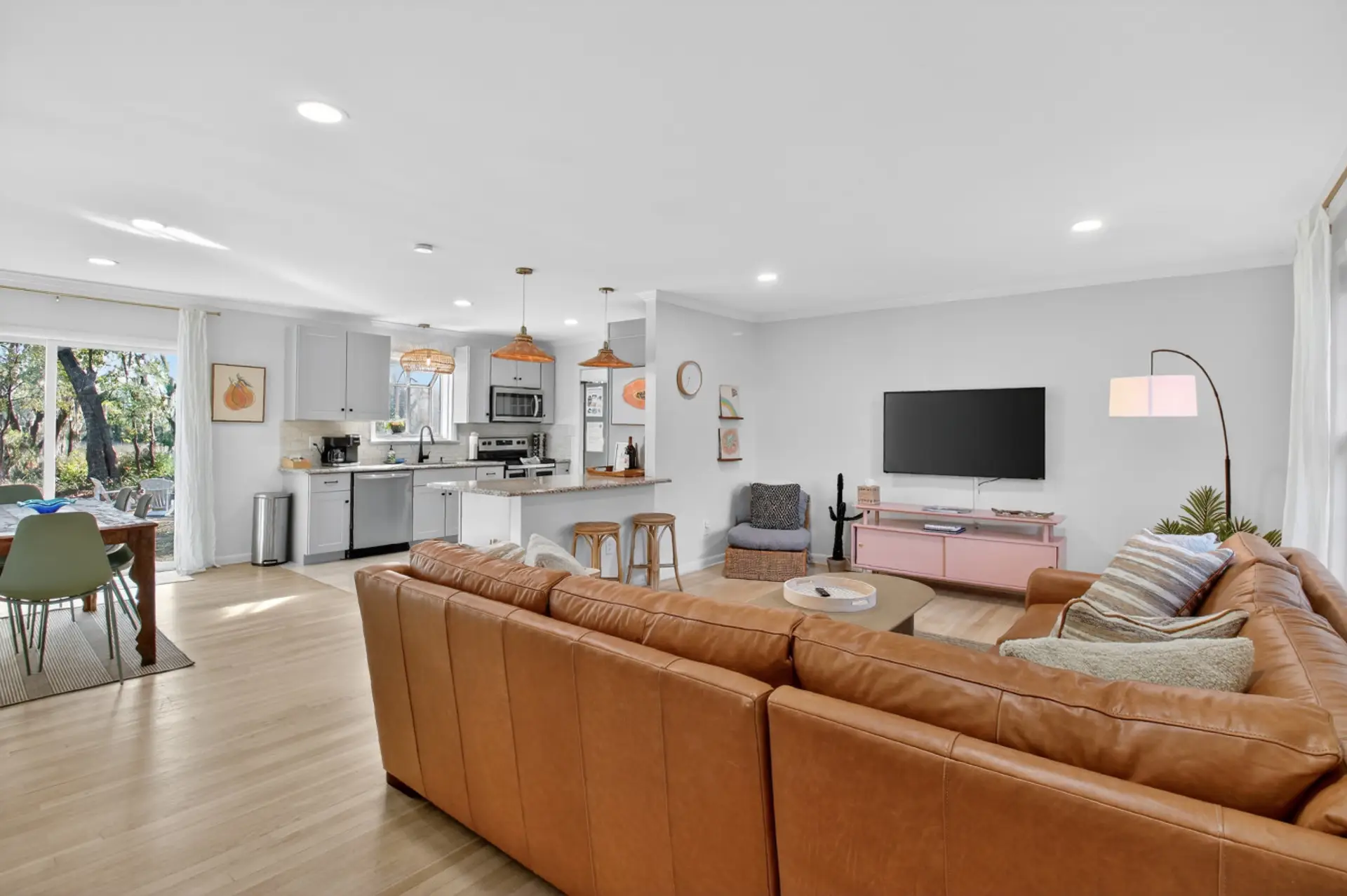 Open, airy, and plenty of room to spread out - the kind of space where everyone finds their spot, whether it's the big leather sectional or a barstool with marsh views