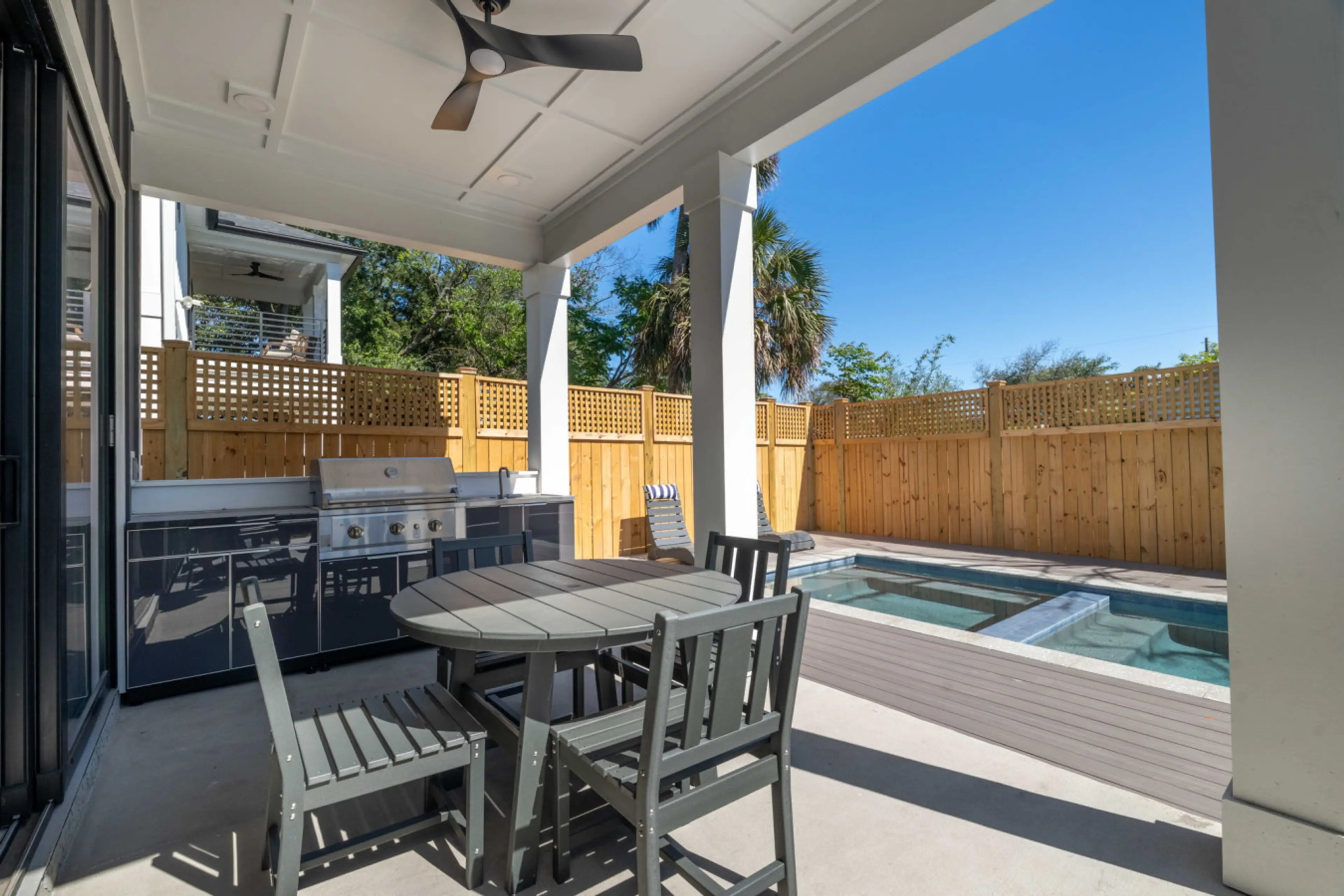 Back patio dreams 🌴✨ featuring a full outdoor kitchen, propane grill 🔥, sink, dining table 🍽️, and your own pool + hot tub 💦🛁