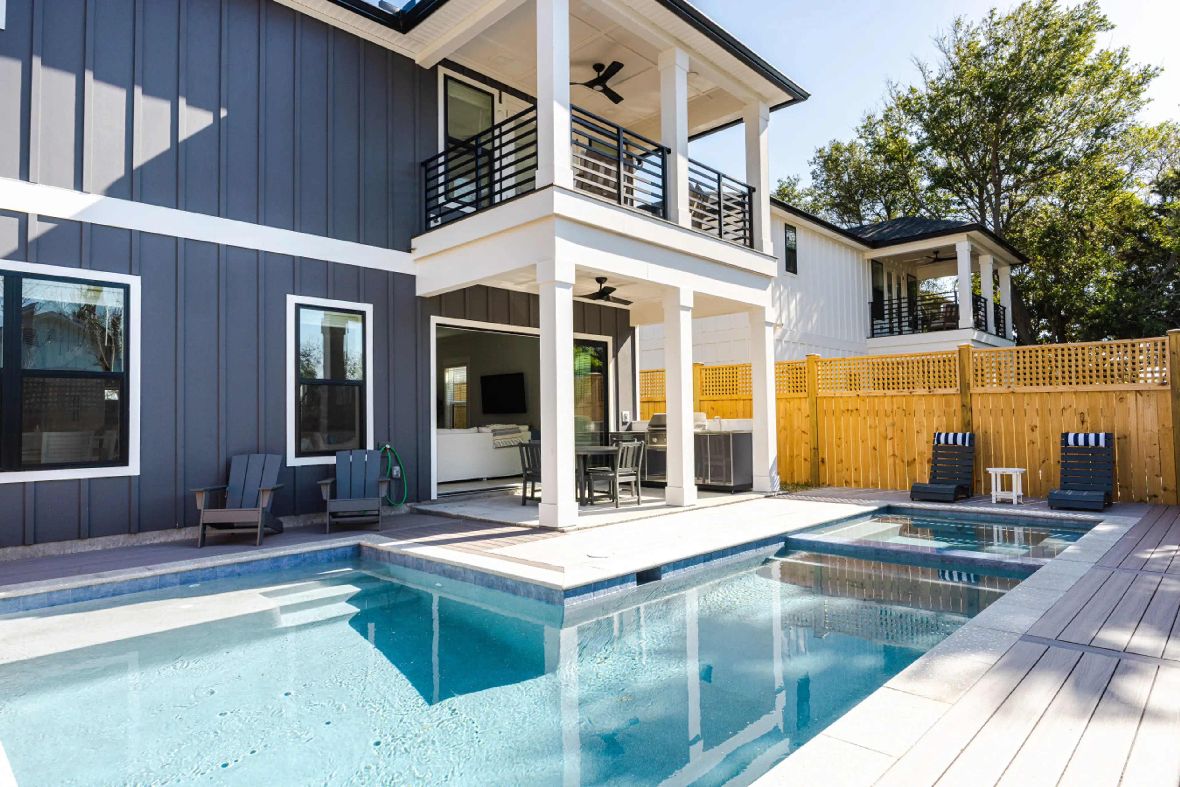 Relax and unwind in your private backyard oasis featuring a heated pool, hot tub, outdoor kitchen with gas grill, and plenty of seating for the whole group ☀️