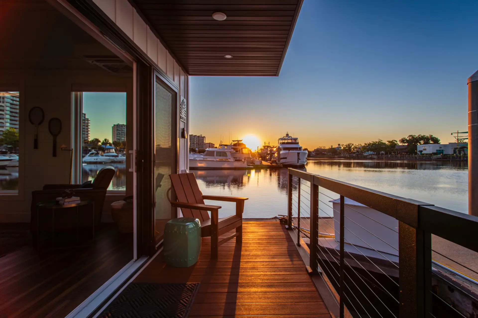 The entry deck at sunrise, where the Adirondack chair faces out over the marina as the sun rises above the Intracoastal.