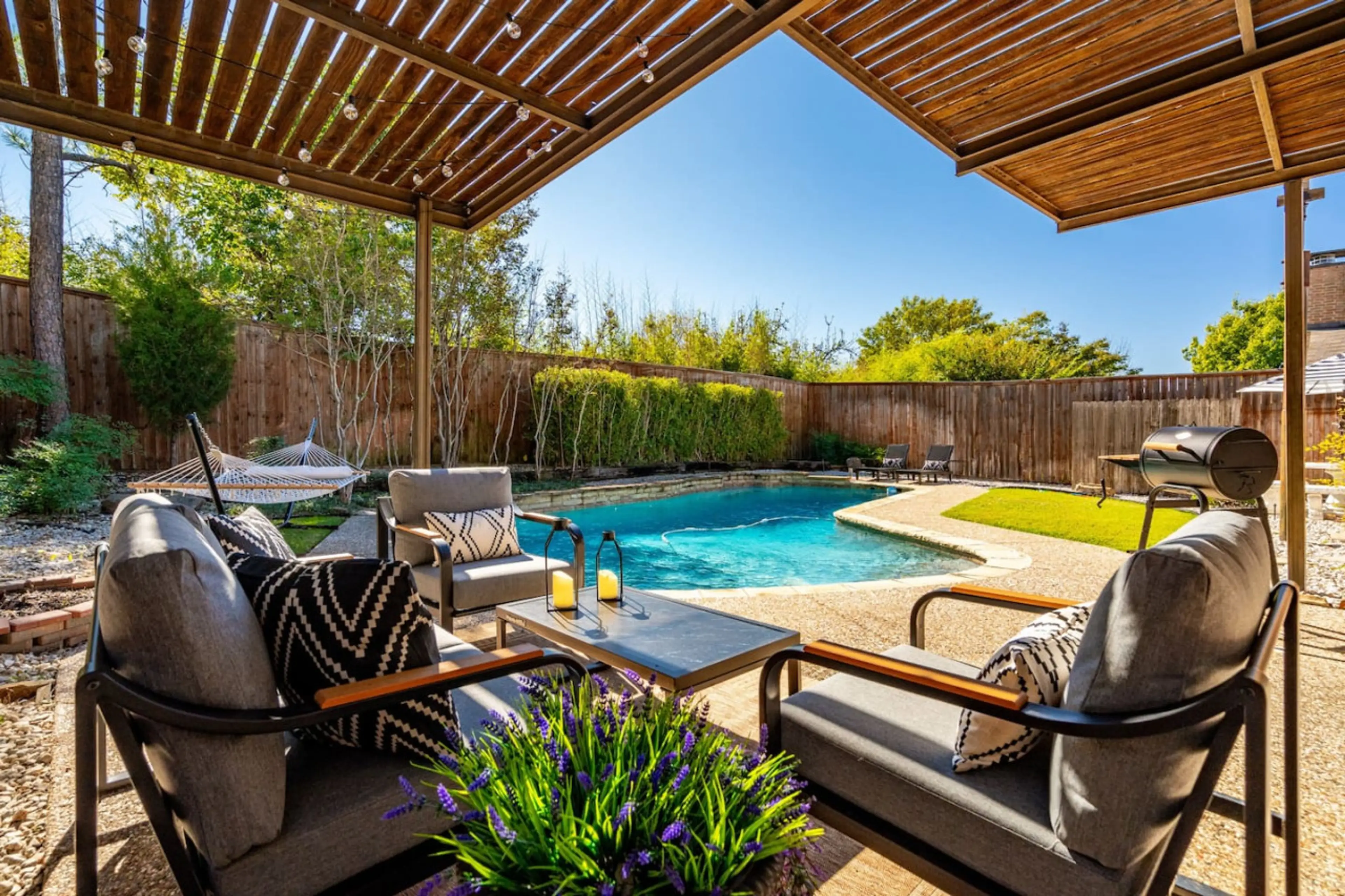 View of the backyard overlooking the pool, outdoor furniture, and a hammock