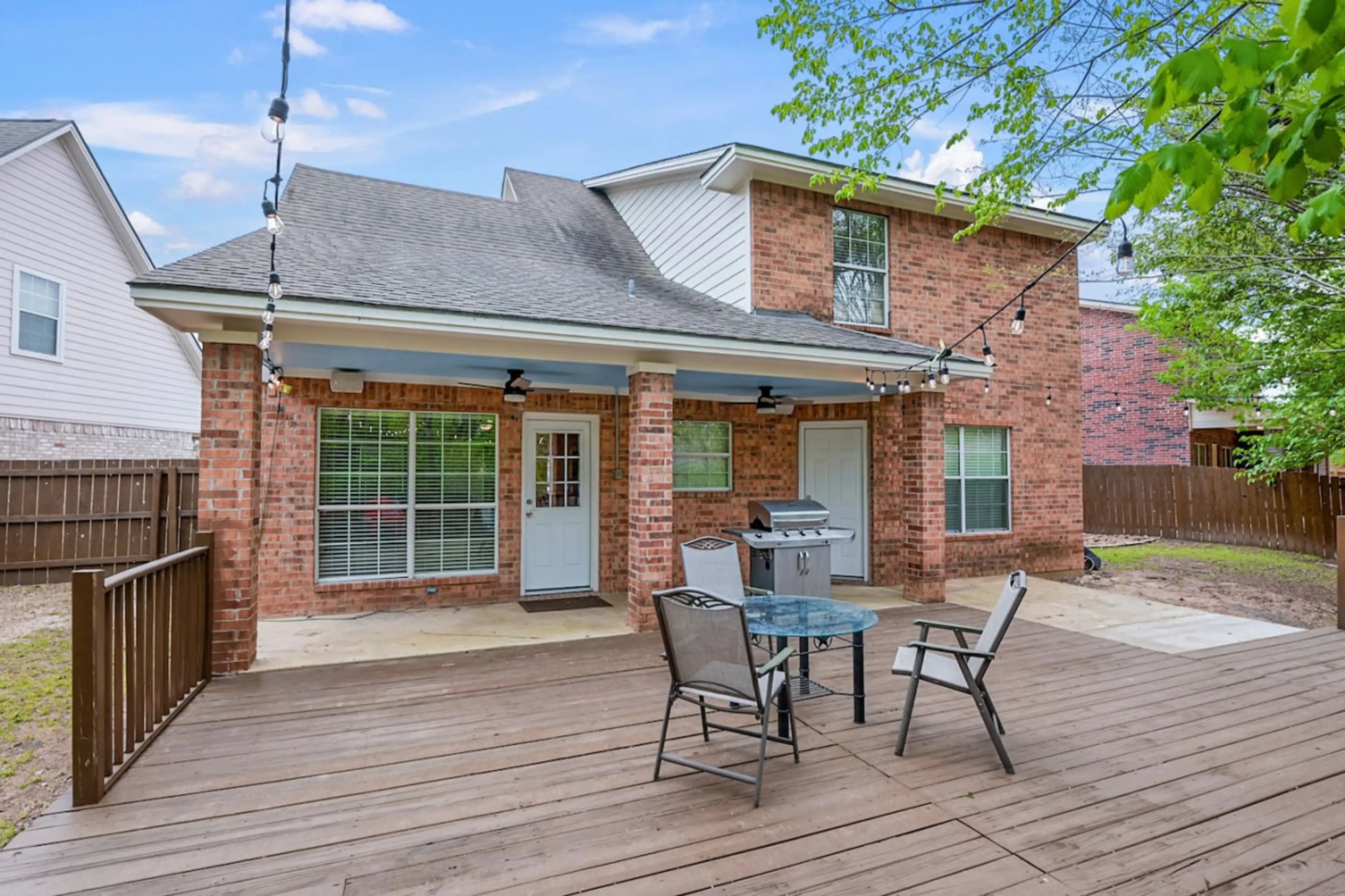Deck in the backyard with seating and hanging lights