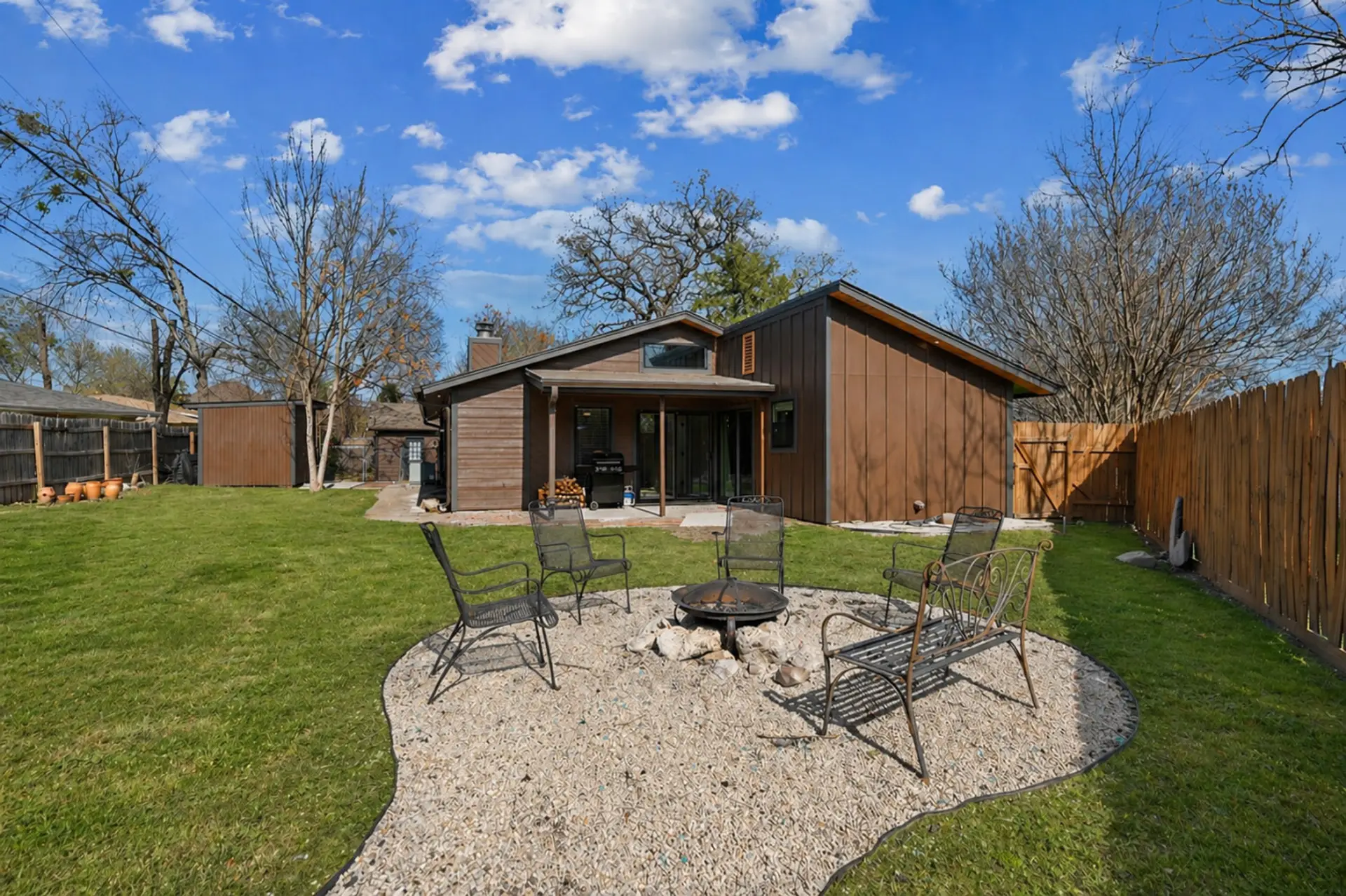 Cozy fire pit surrounded by comfortable seating beckons warm gatherings.