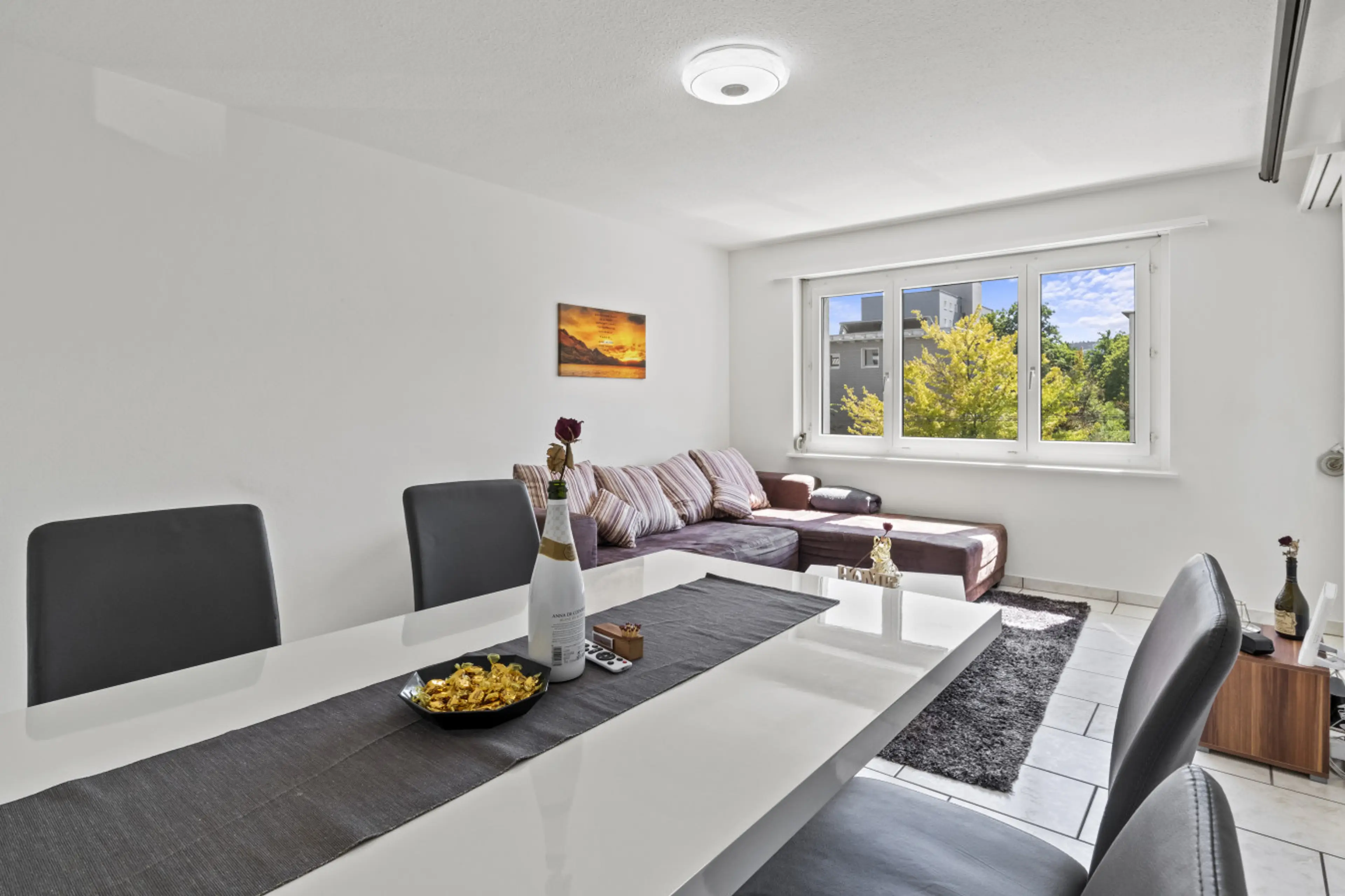 Dining area with big table, stylish chairs and cosy lounge corner in the back.