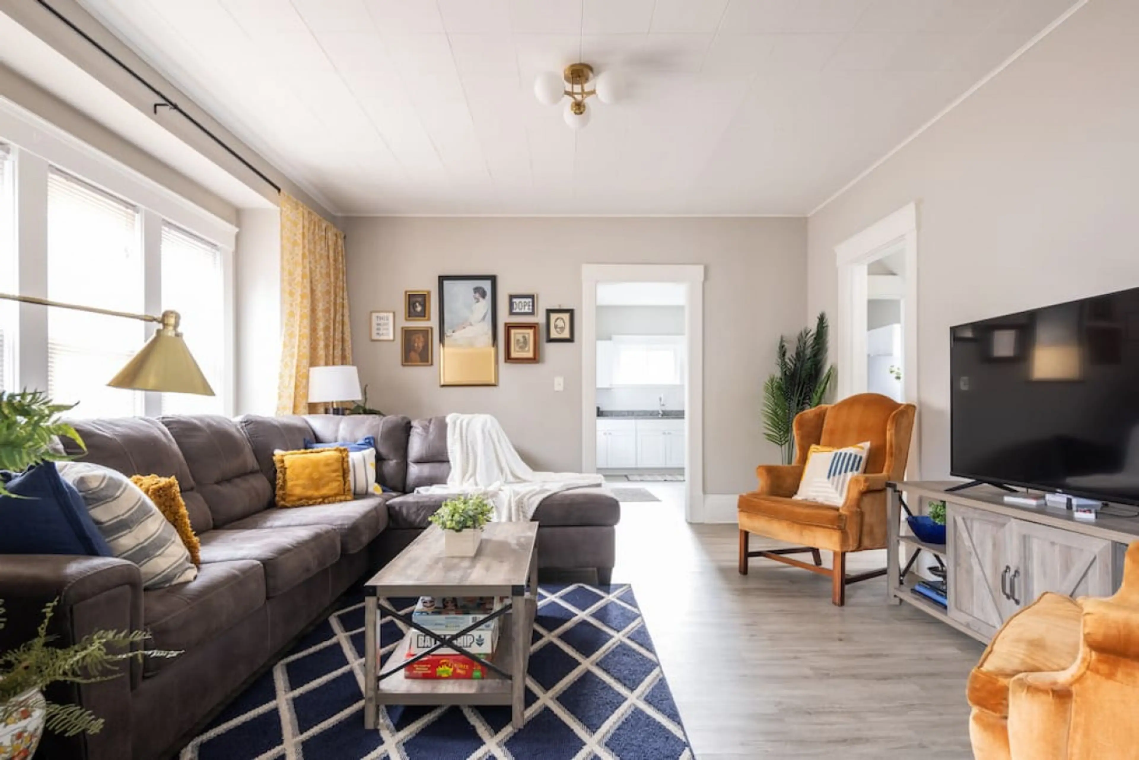 Comfortable living room with smart TV and work desk (work desk is located behind the couch near the wall & pictures).