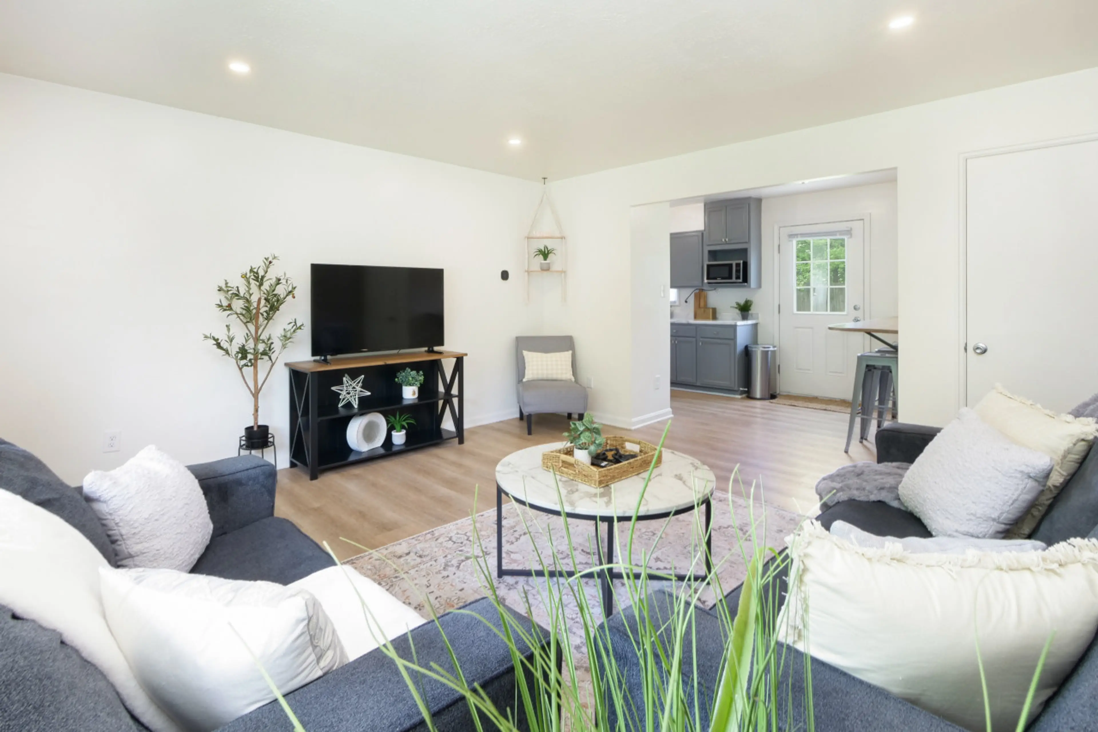 Kick back in the cozy living room 🛋️ with plush seating, a smart TV 📺, and open flow into the kitchen for easy entertaining 🍃. Soft lighting and natural touches create a calm, welcoming space to relax.