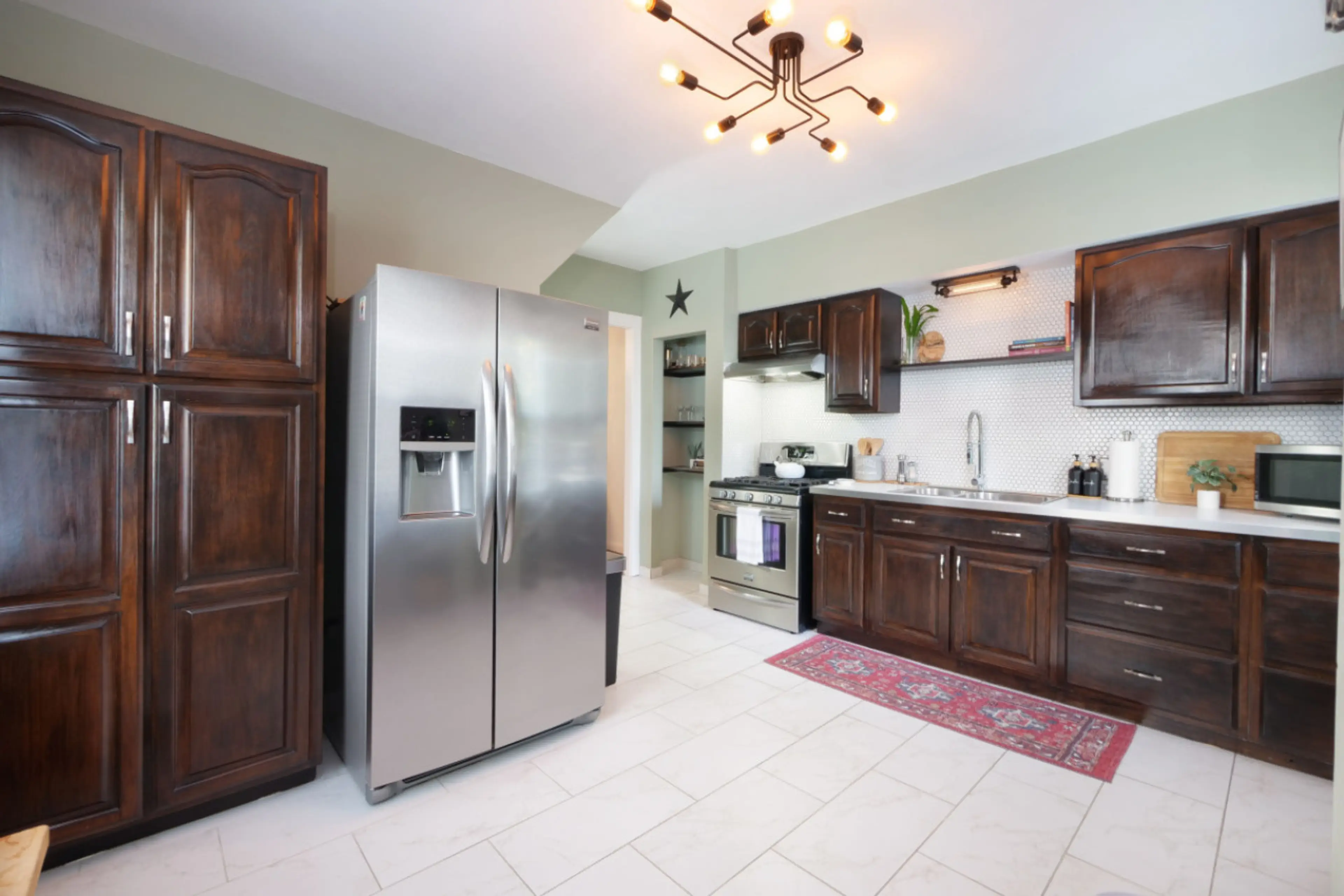Cook like a pro in this fully equipped kitchen featuring stainless steel appliances, rich wood cabinetry, and open shelving for a modern touch. Perfect for family meals or morning coffee! ☕🍳