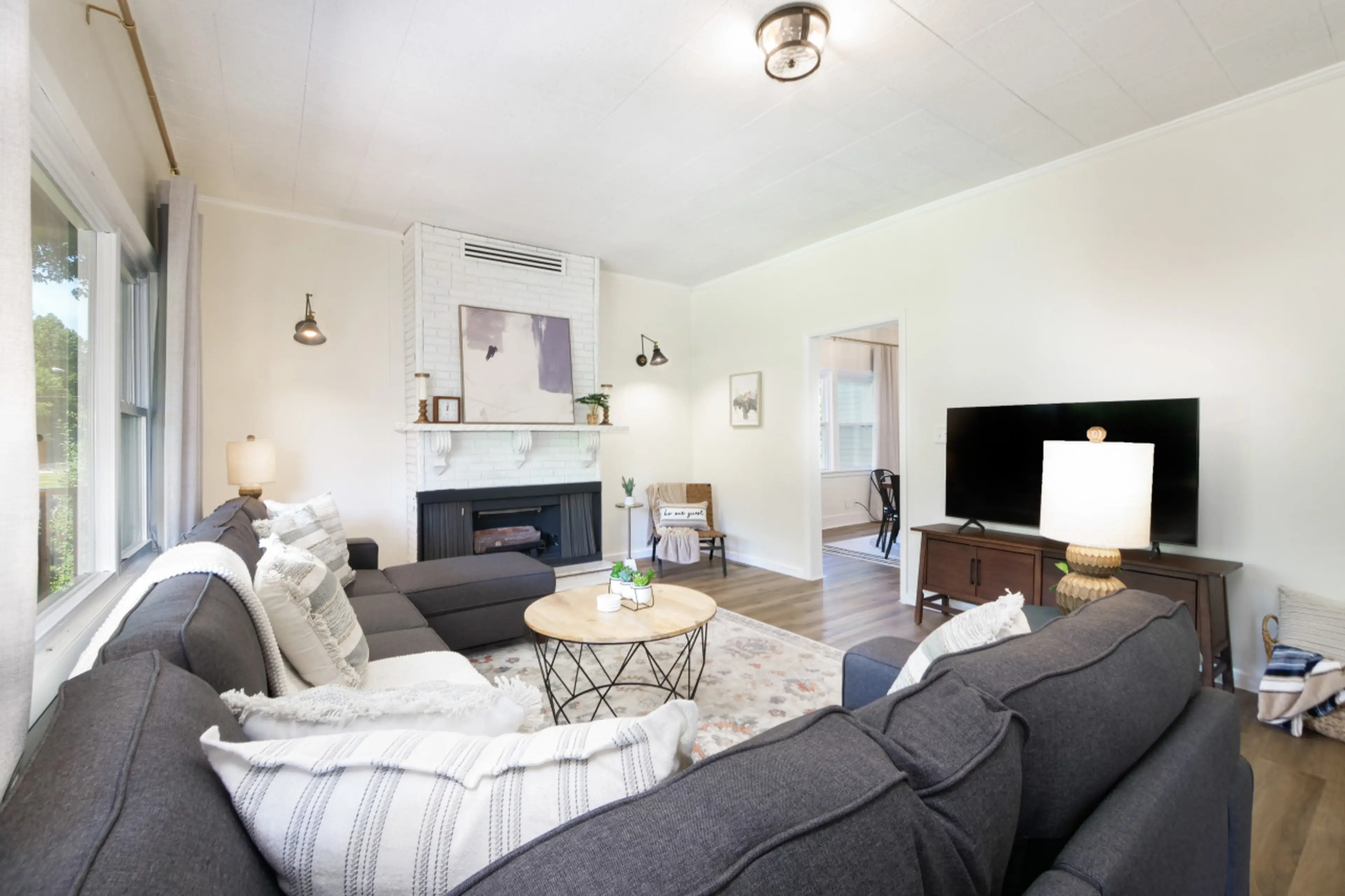 Relax in this bright & cozy living room featuring a plush sectional, smart TV, and charming fireplace 🛋️🔥 Perfect for movie nights, board games, or curling up with a book 📚✨