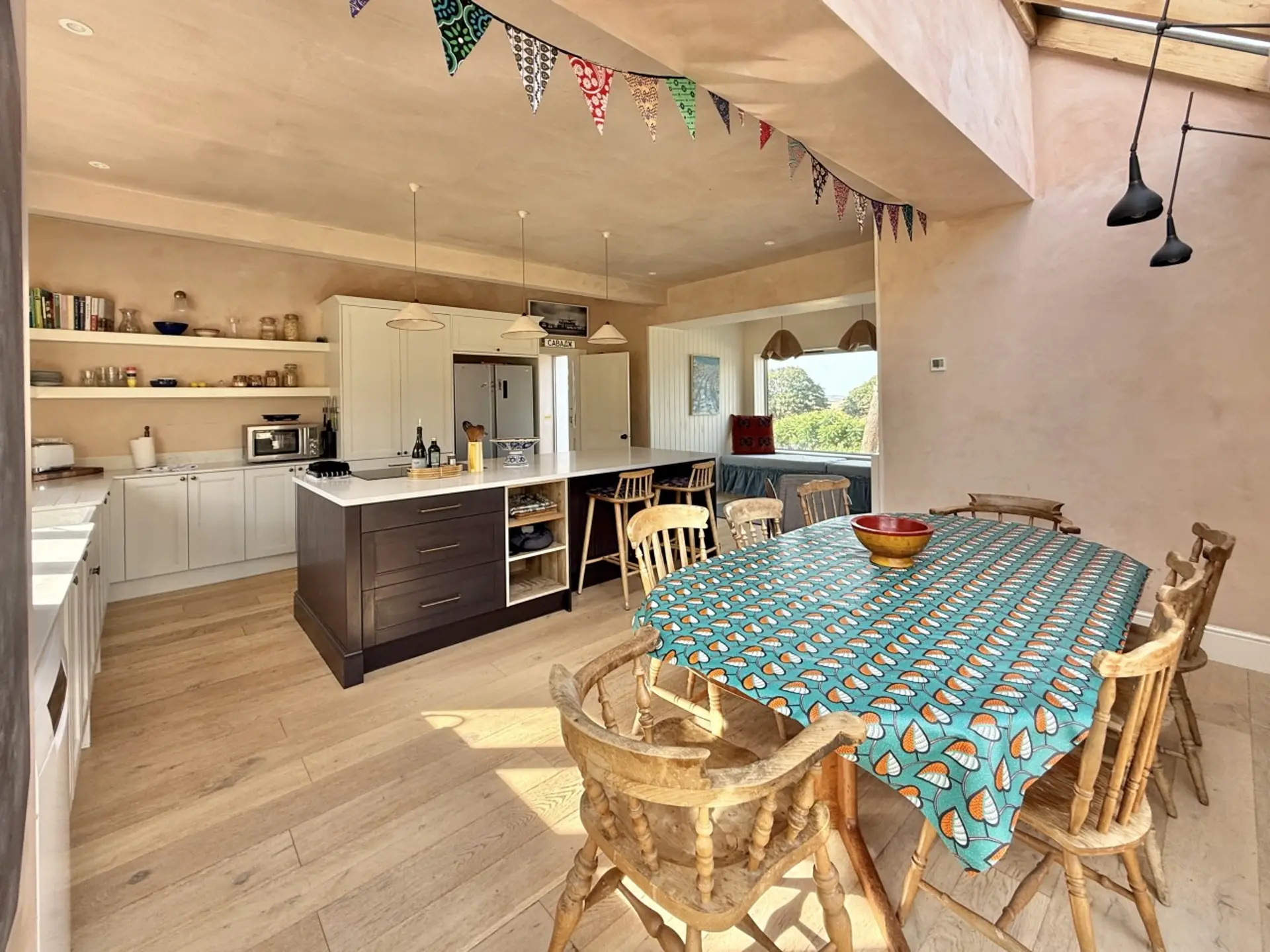 Open plan living with kitchen and dining area and access to the garden plus picturesque window with seat