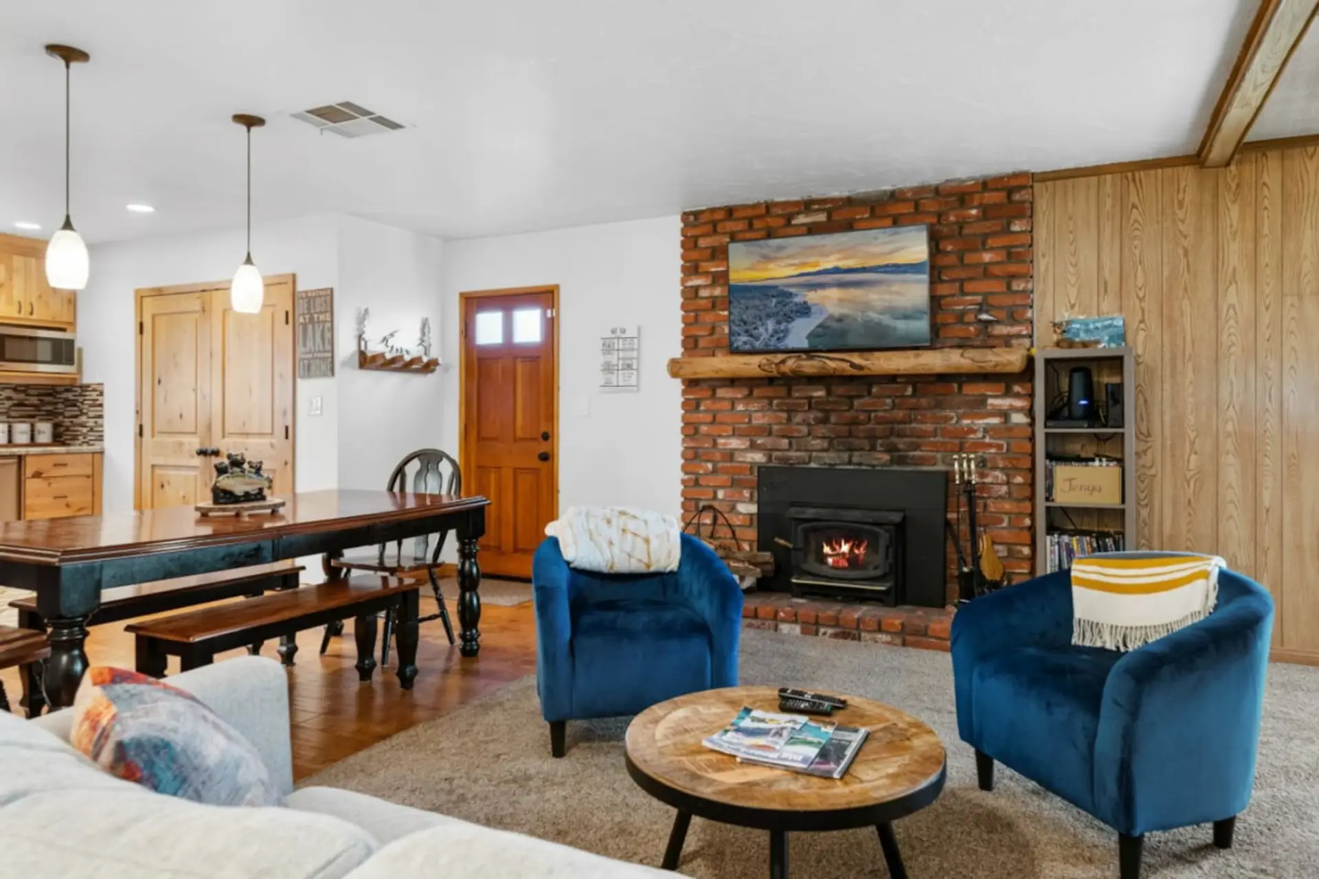 Open living & dining area w/ stone fireplace, cozy seating, and rustic touches for relaxed group gatherings.
