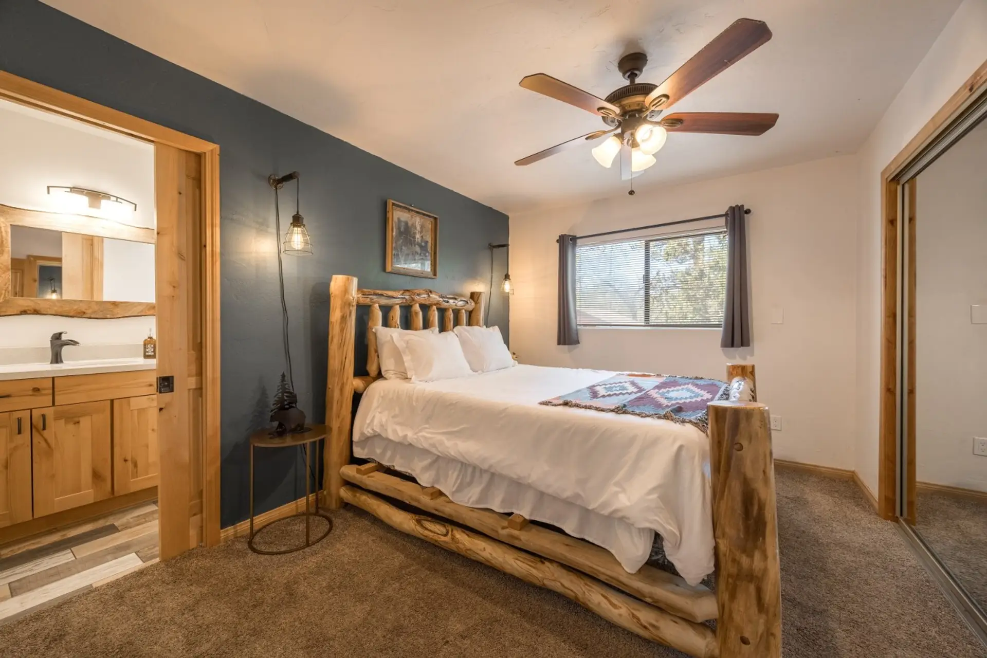 Bedroom w/ log-frame bed, cozy quilt & en-suite bath just steps away.