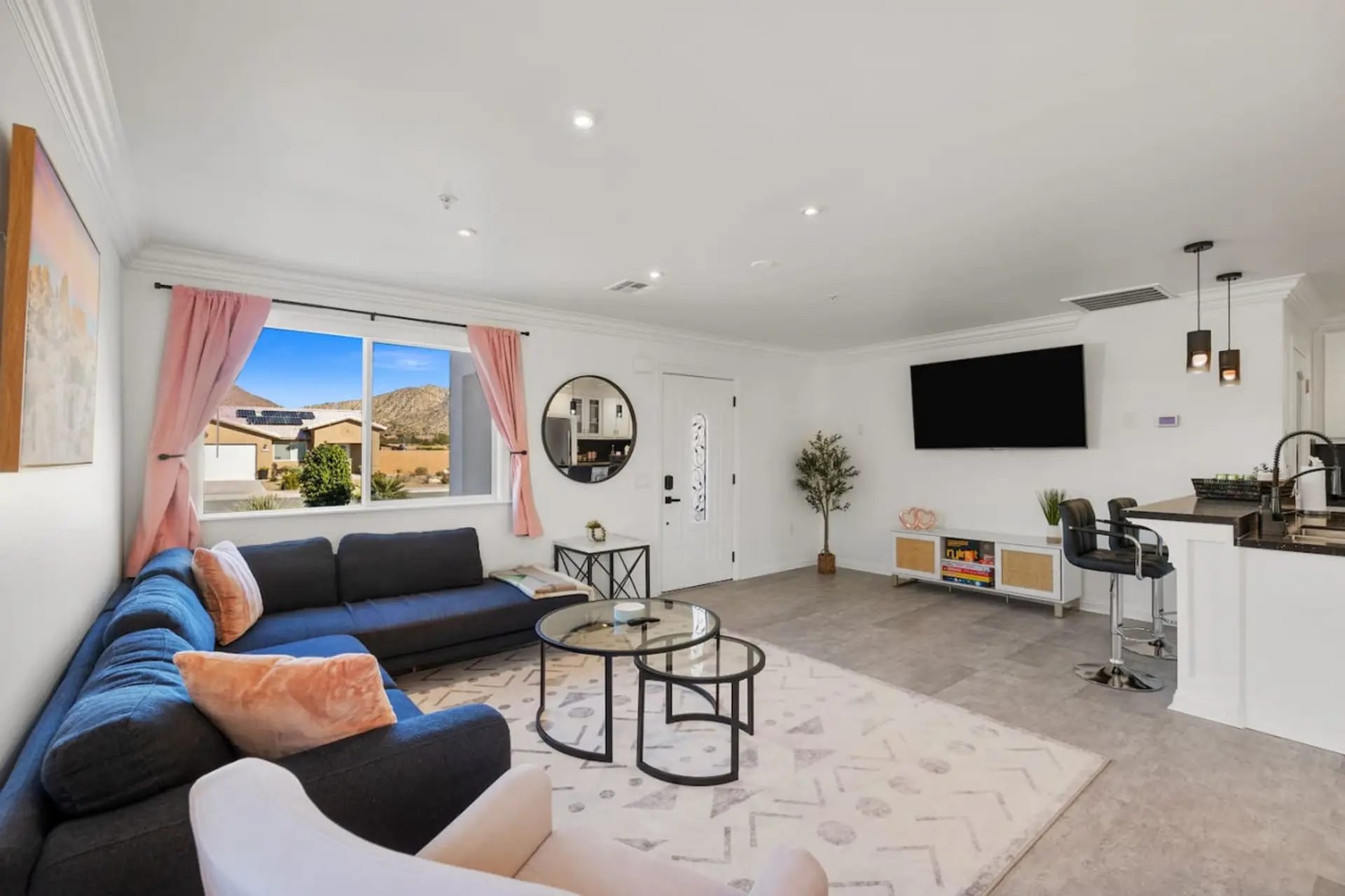 Bright, open living room w/ comfy seating, wall-mounted TV & easy flow to the rest of the home.
