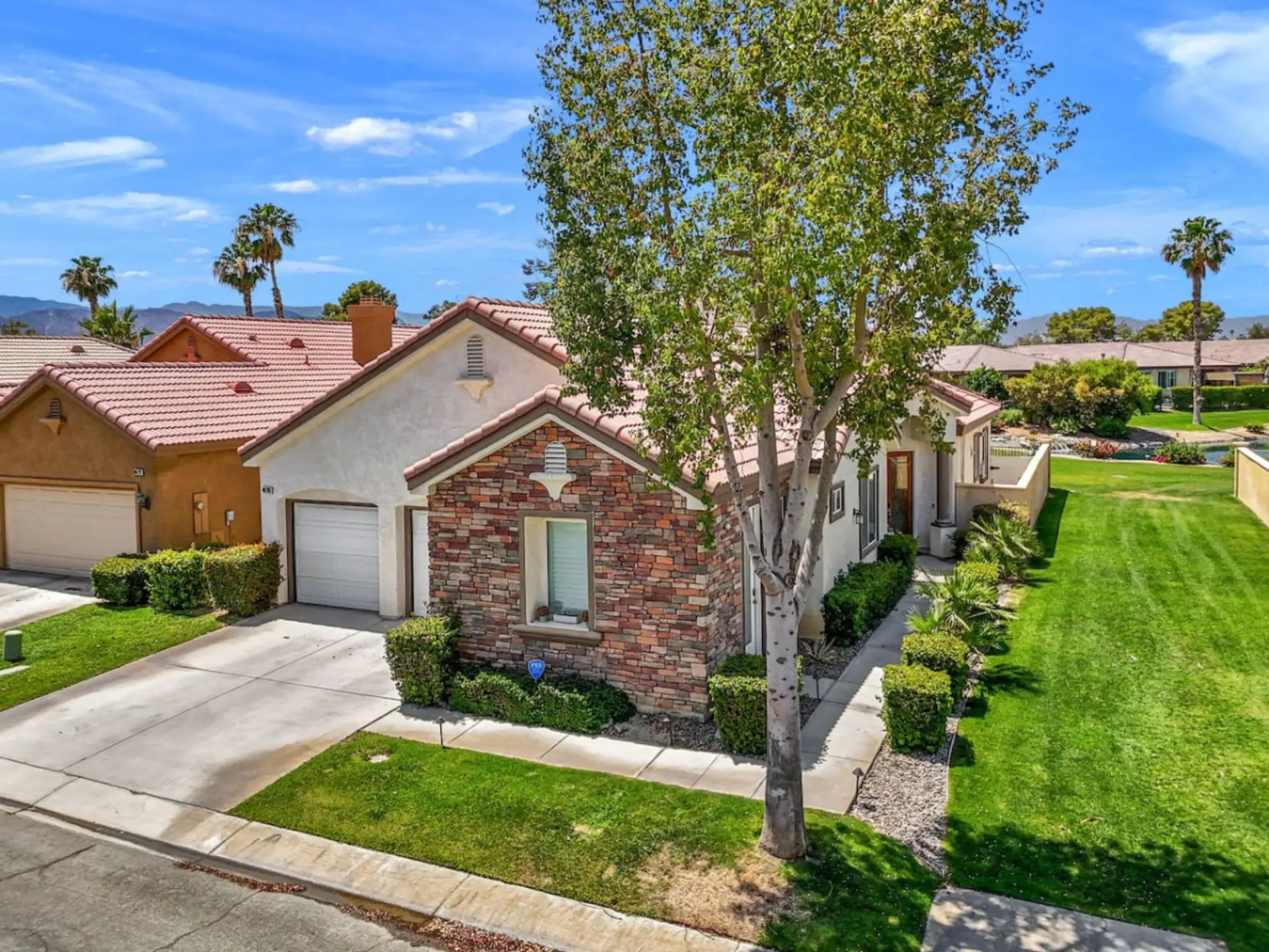Charming exterior view showcasing tidy landscaping & welcoming curb appeal.