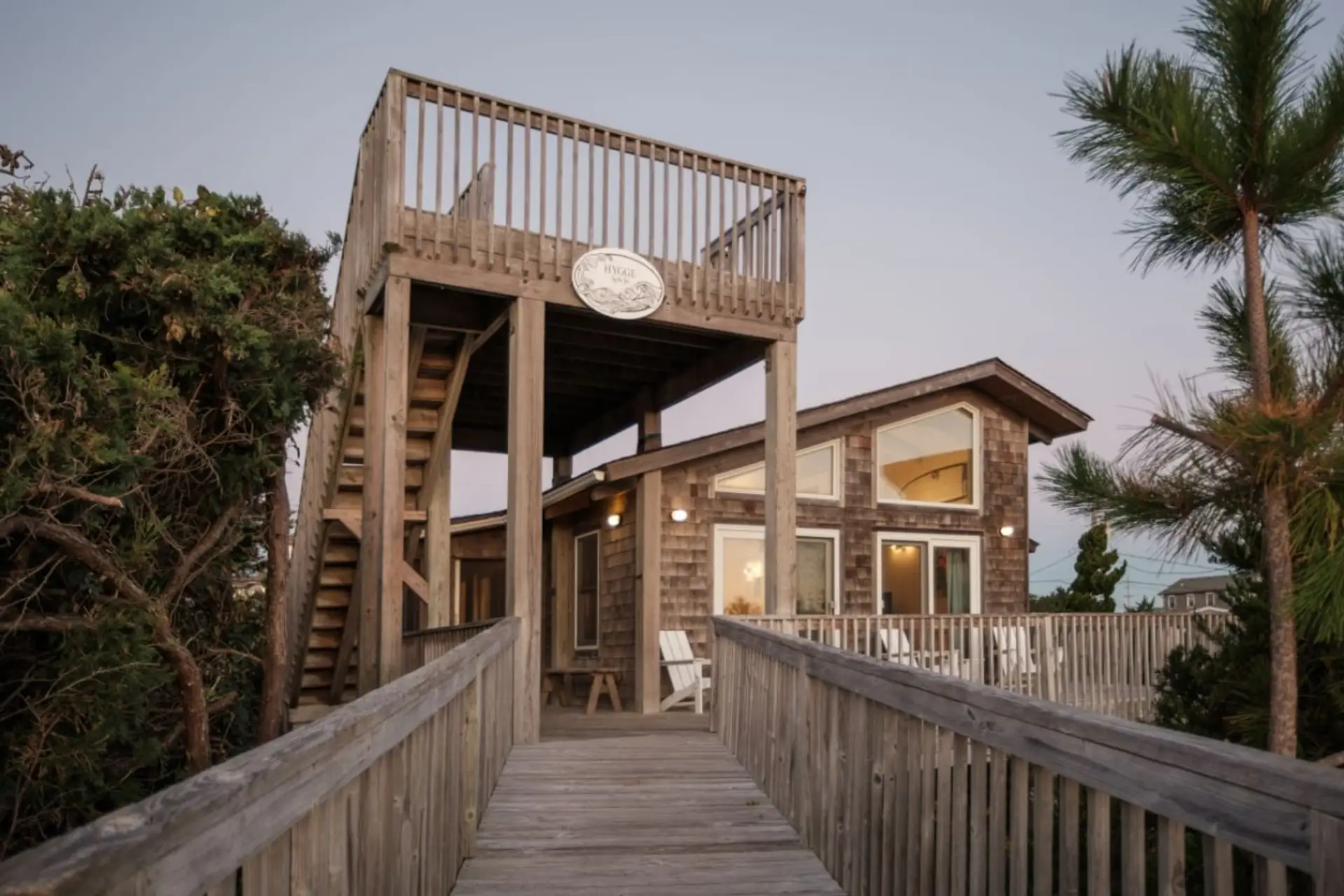Elevated exterior walkway leading to the home, surrounded by natural greenery.