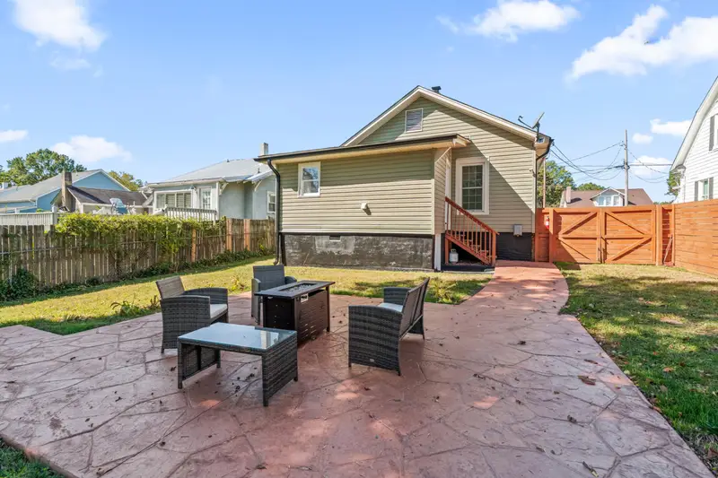 Private fenced backyard with propane firepit for evening gatherings at Hygge High Point pet-friendly rental
