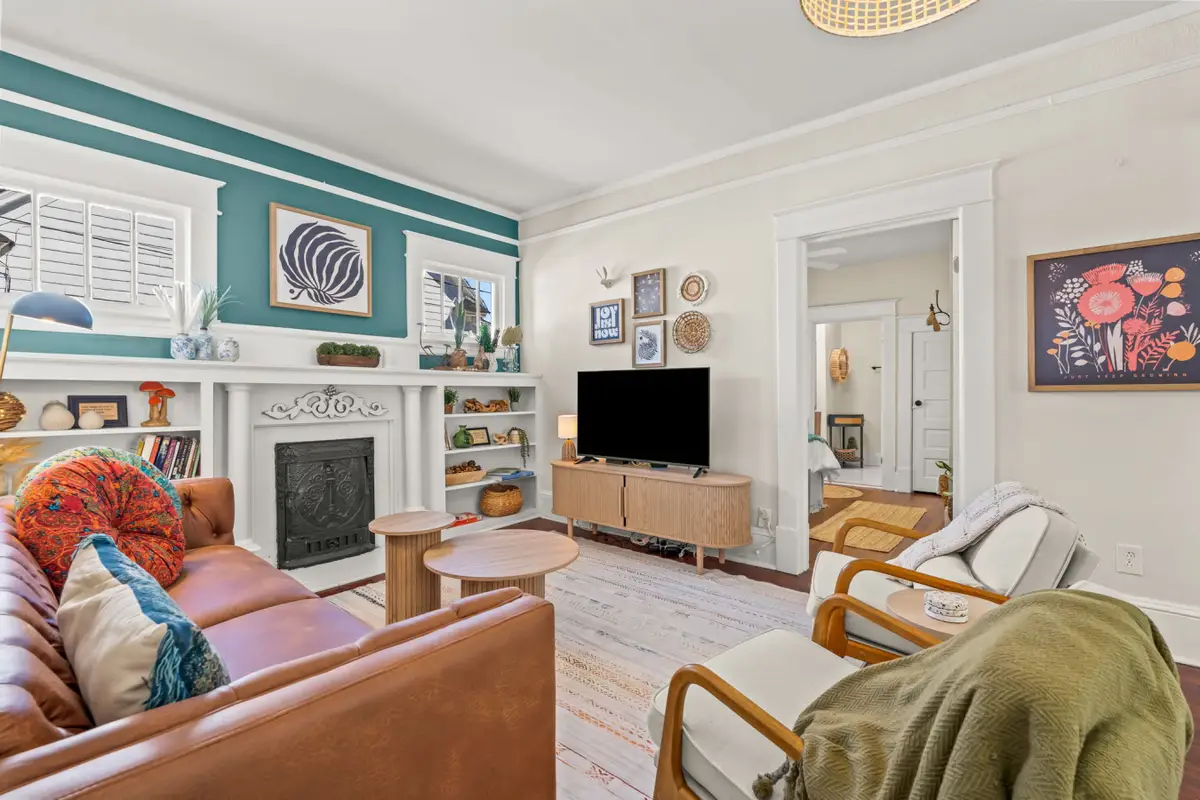 Cozy boho living room with preserved 1920s hardwood floors and curated vintage furniture at Hygge High Point