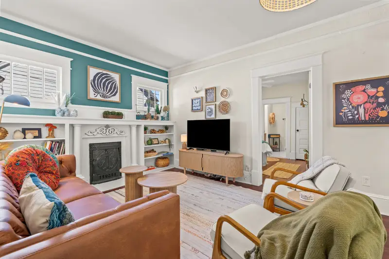 Boho-styled living room with original 1920s hardwood floors and curated vintage decor at Hygge High Point vacation rental High Point NC