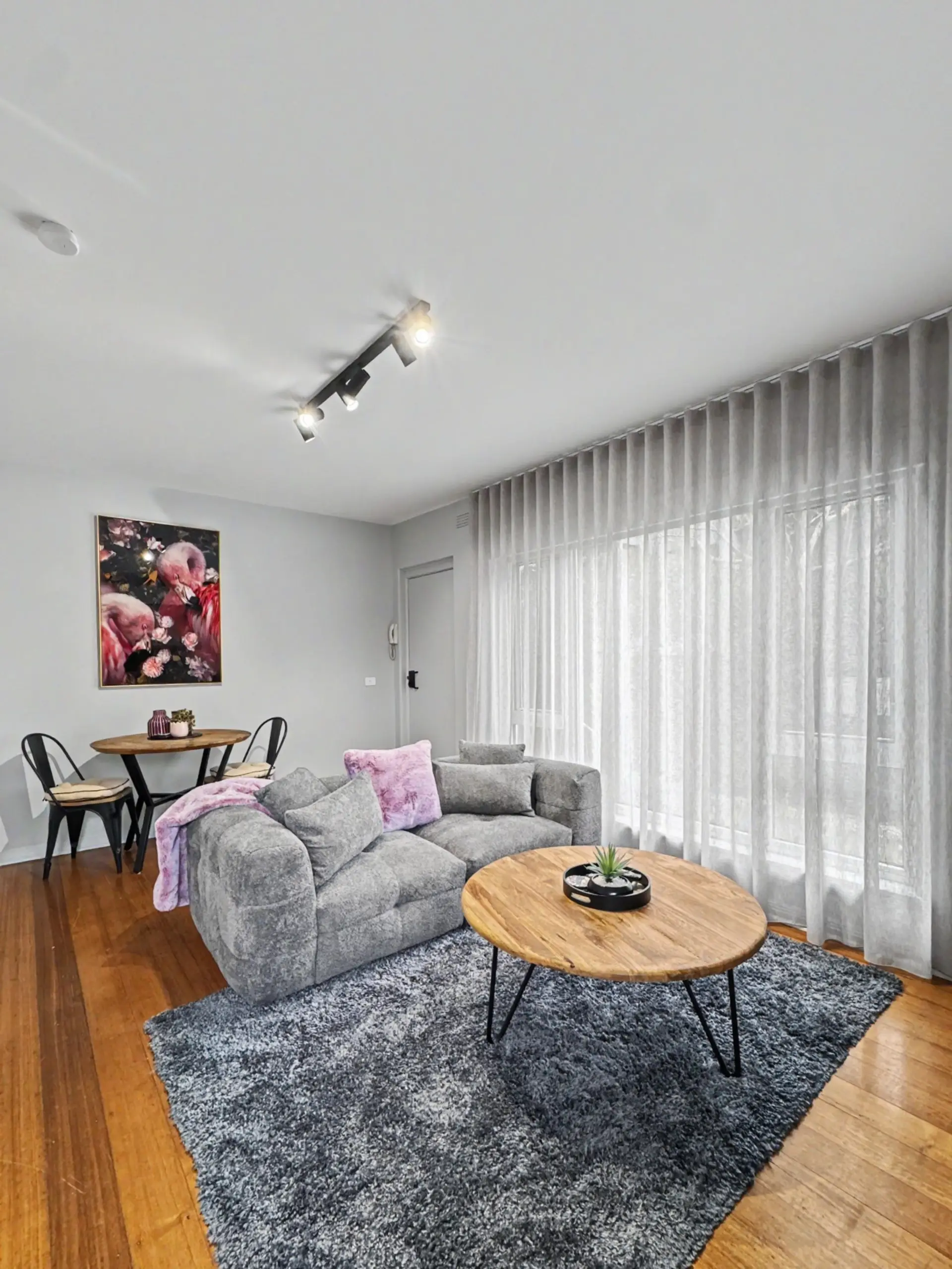 A bright, welcoming open-plan space with warm timber floors, a comfortable lounge and a fully equipped kitchen, perfect for settling in and feeling at home