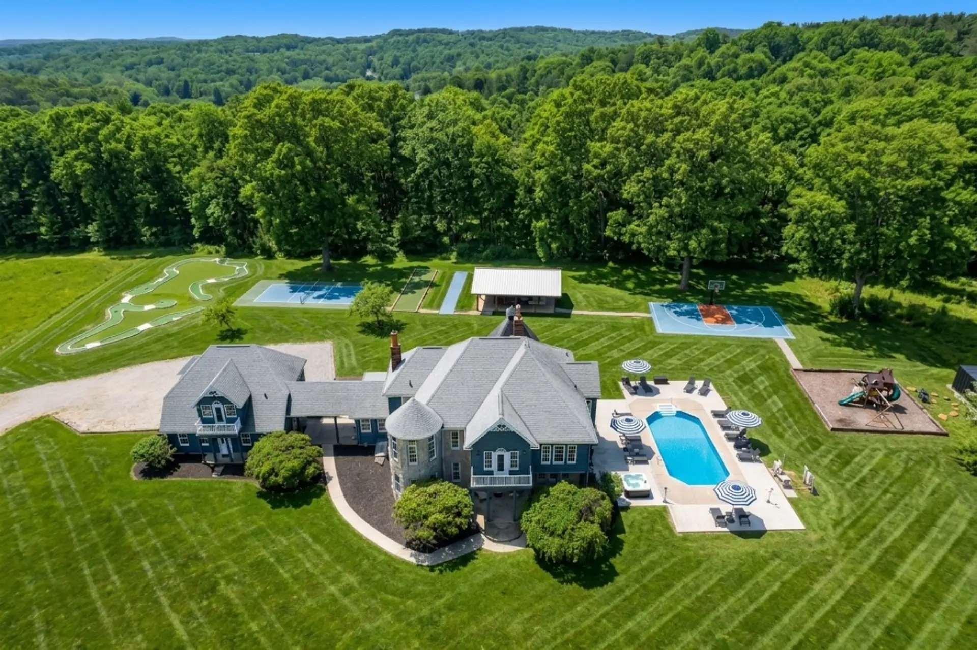 [Resort Property] Aerial view of property with heated pool, pickleball court, basketball, shuffleboard, bocce, playground and more!