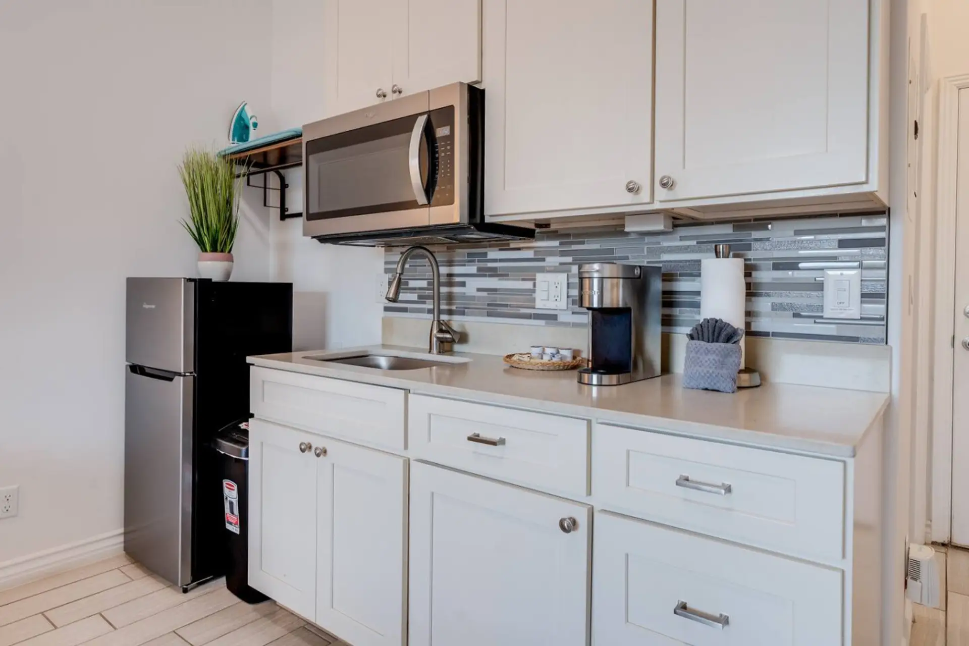 Kitchenette equipped with essential tools for preparing small meals. There is no stove or oven, but it includes a portable hot plate, skillet, and other basic cookware