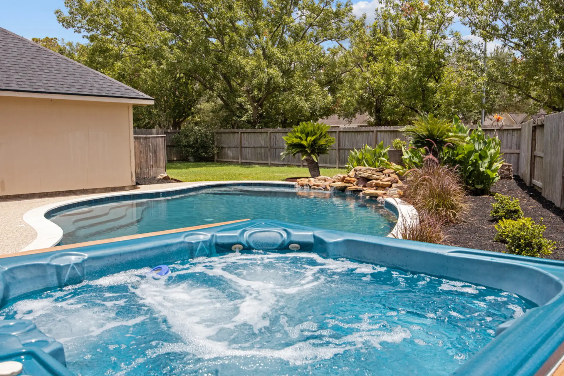 Private backyard oasis with pool, hot tub, and landscaped surroundings—your personal Cypress retreat.