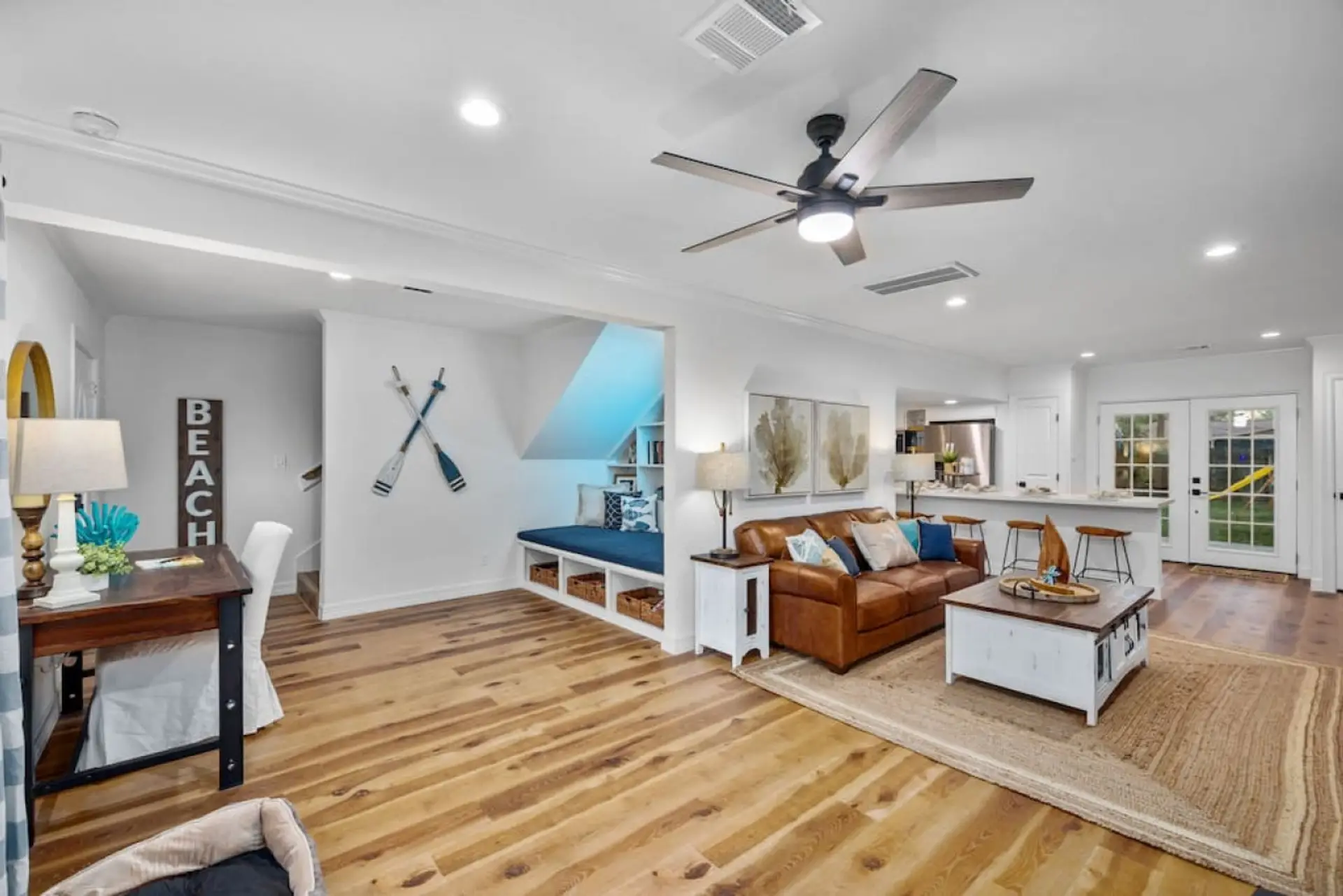 Bright open-concept living space with cozy seating, workspace nook, and fully equipped kitchen — perfect for gathering, relaxing, or working remotely.